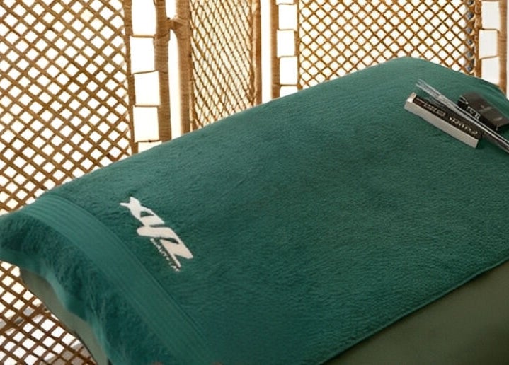 Calming massage bed at XYZ Beauty Lab in London, England, GB with branded towel.