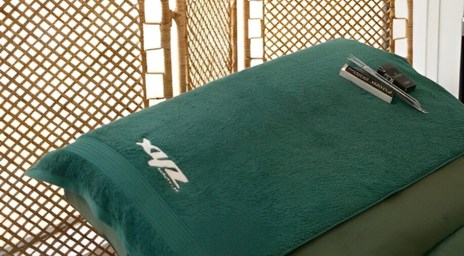 Calming massage bed at XYZ Beauty Lab in London, England, GB with branded towel.