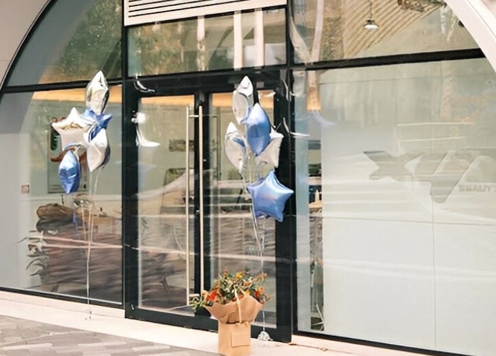 Front of XYZ Beauty Lab in London, England, GB with star-shaped balloons and a welcoming bouquet.