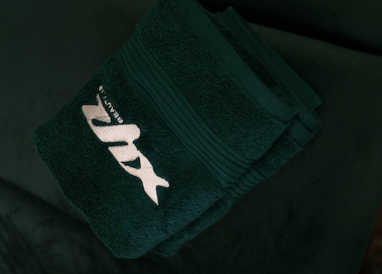 Plush green towels with XYZ Beauty Lab logo, London, England, GB.