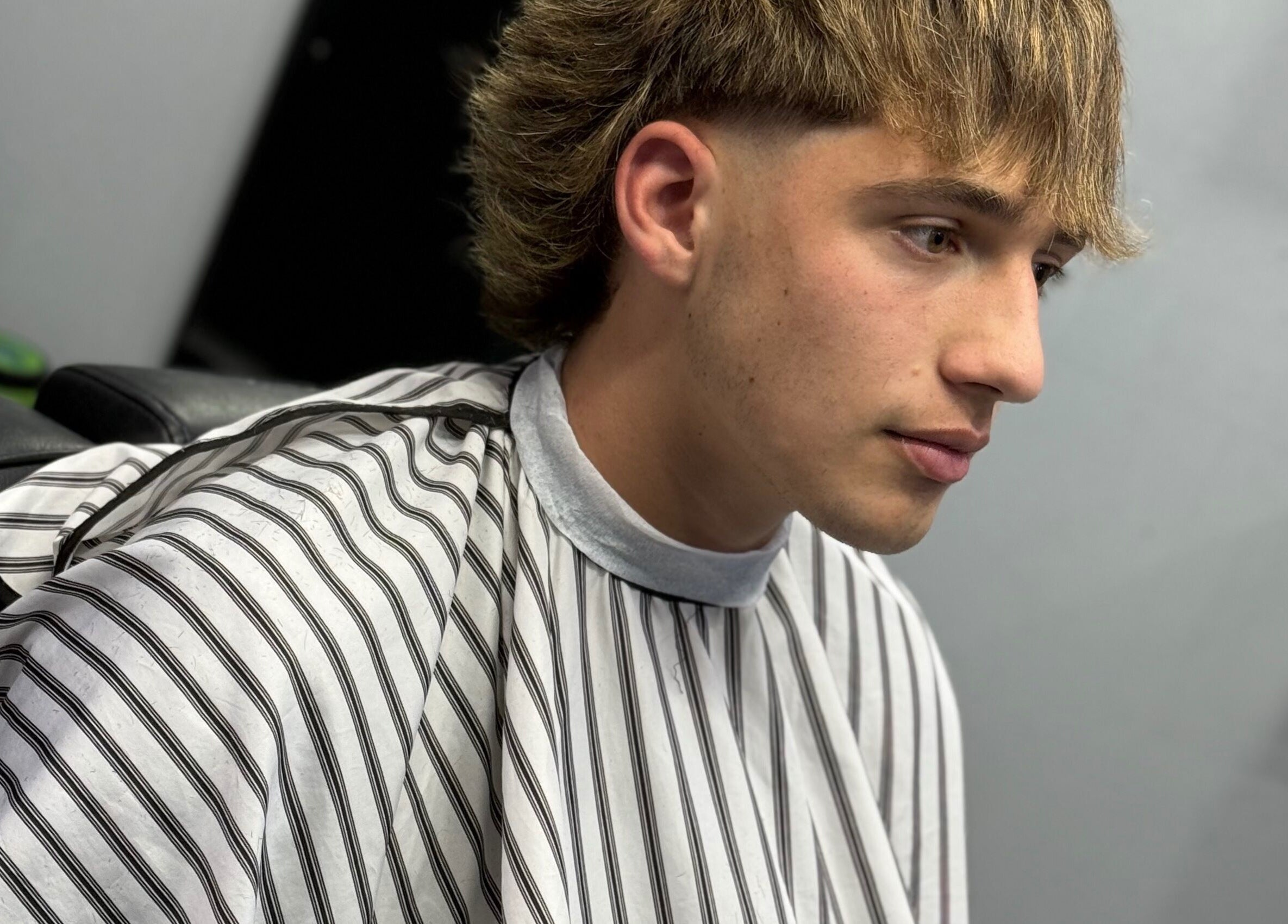 Joven en Southside Barbershop, Iuf, Santa Fe, AR con corte moderno y elegante.