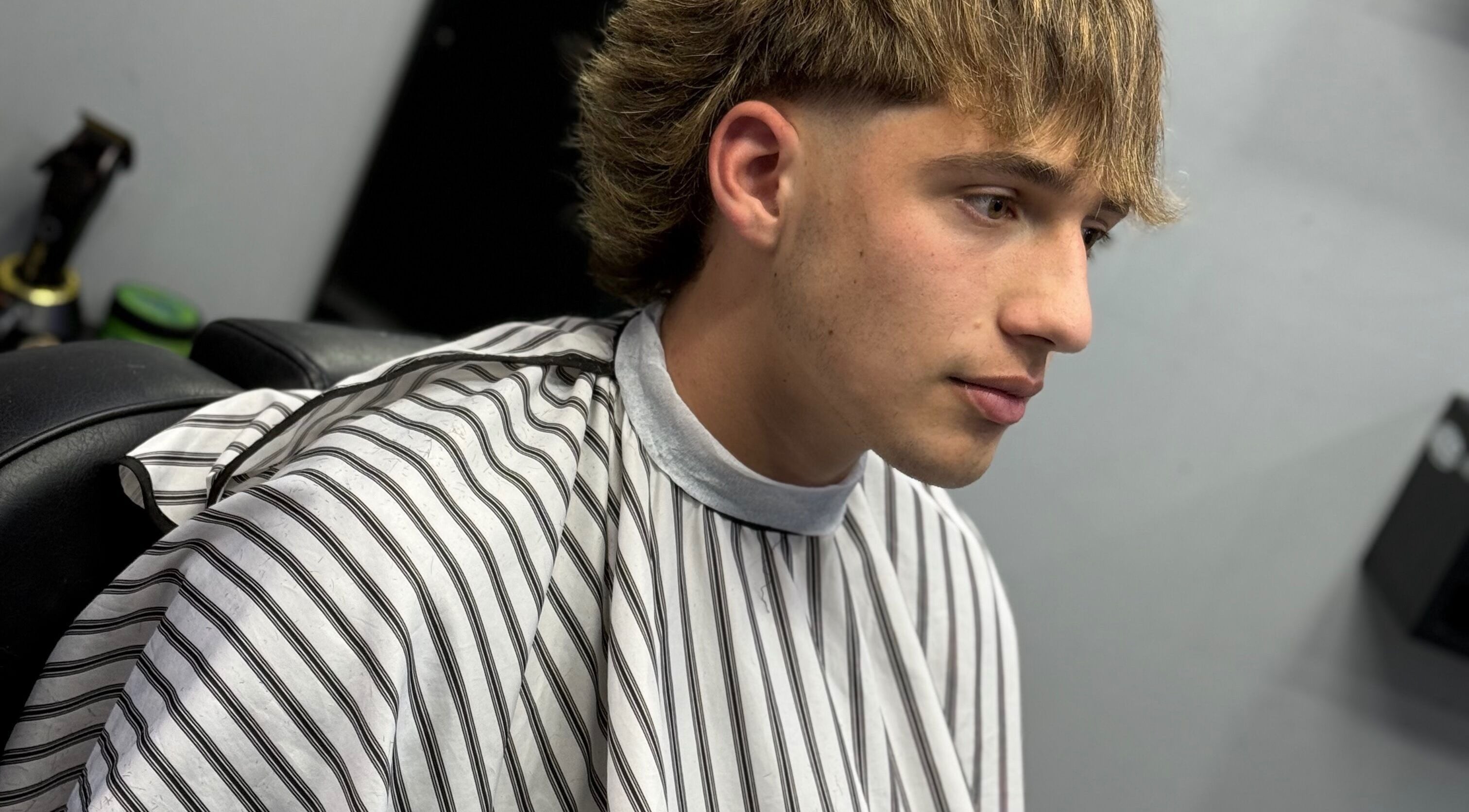 Joven en Southside Barbershop, Iuf, Santa Fe, AR con corte moderno y elegante.