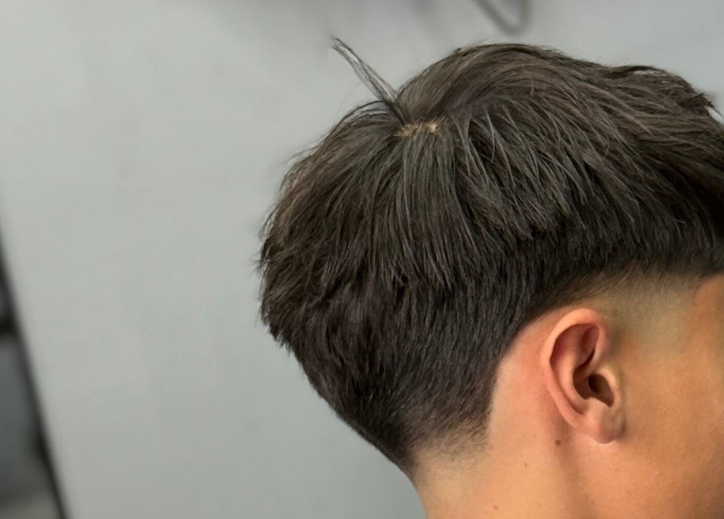 Corte de cabello juvenil en Southside Barbershop, Iuf, Santa Fe, AR, mostrando un estilo moderno.