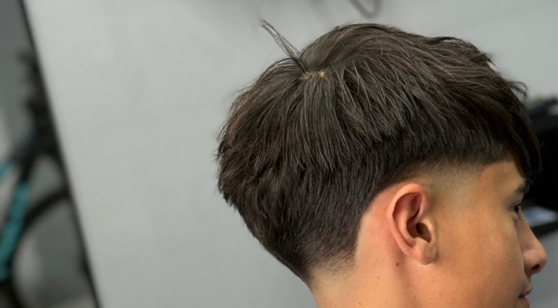 Corte de cabello juvenil en Southside Barbershop, Iuf, Santa Fe, AR, mostrando un estilo moderno.