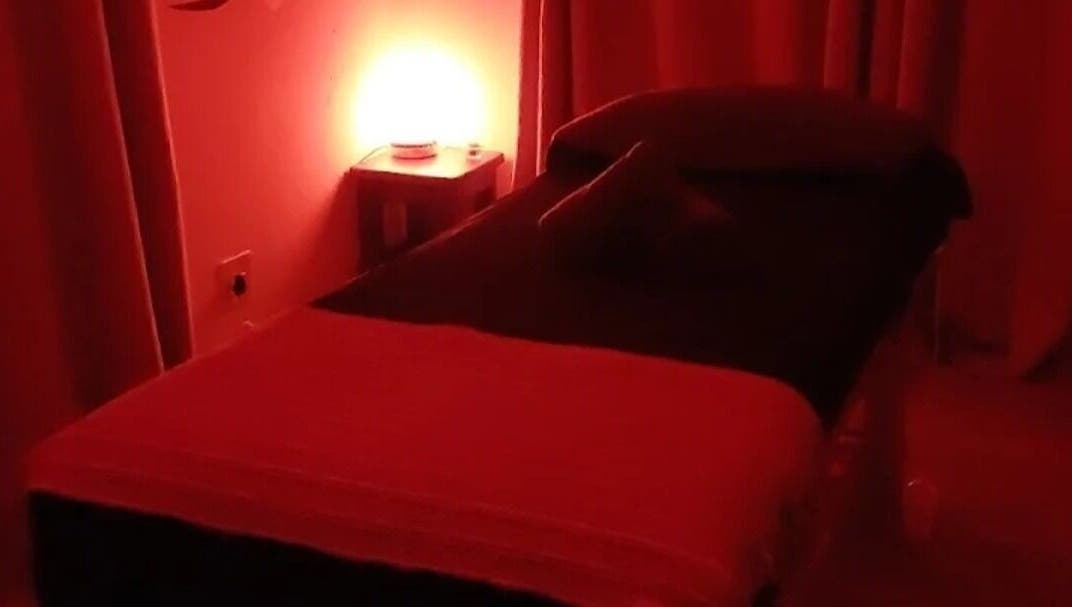 Relaxing massage room at Hazel Sensual Massage Therapist, Cape Town, Western Cape, ZA with ambient red lighting.