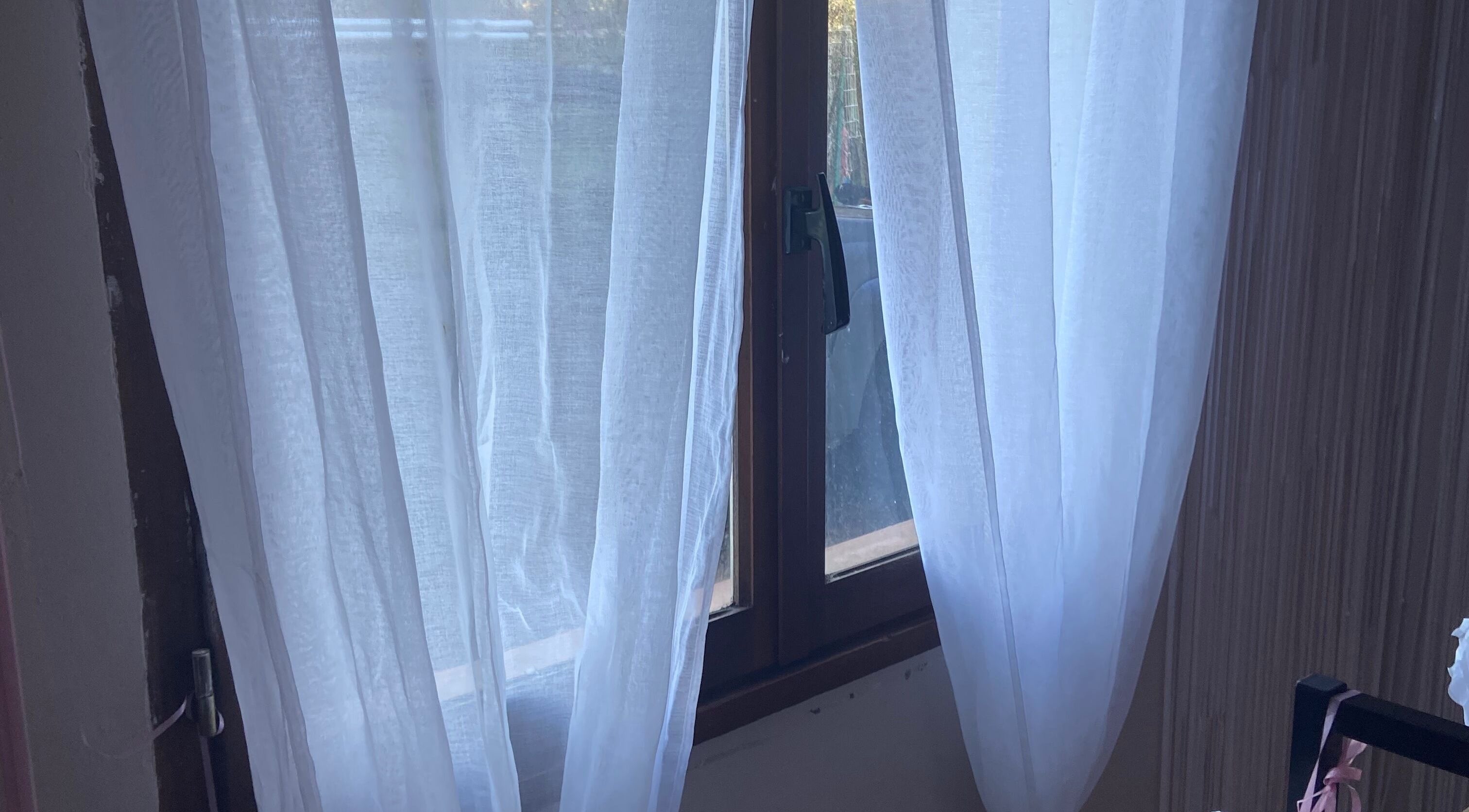 Fenêtre avec rideaux transparents à Coranails, Saint-martin-lalande, Occitanie, FR.