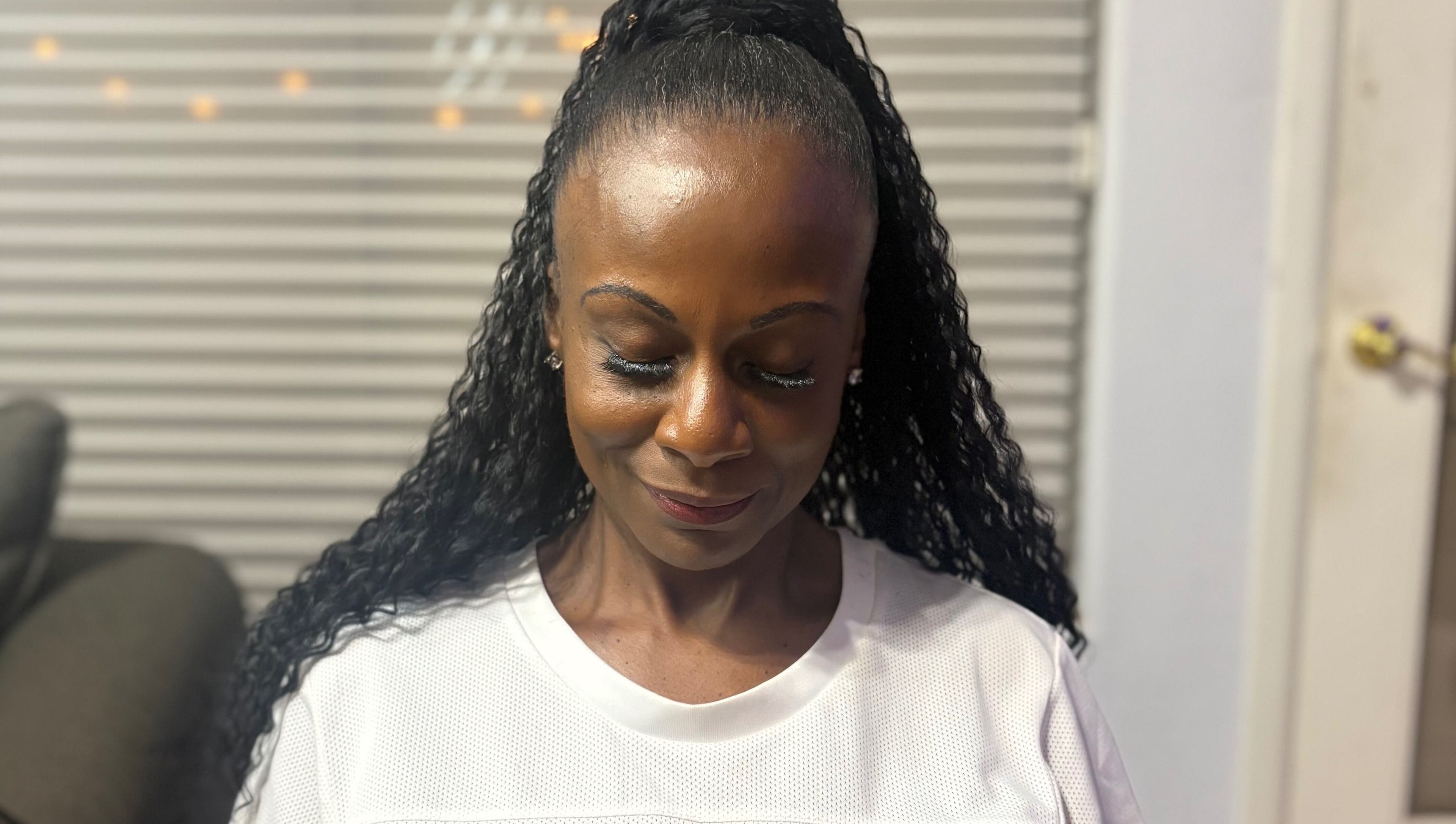 A client with styled hair at CrownedByLanii in El Mirage, Arizona, US, showing calm contentment.