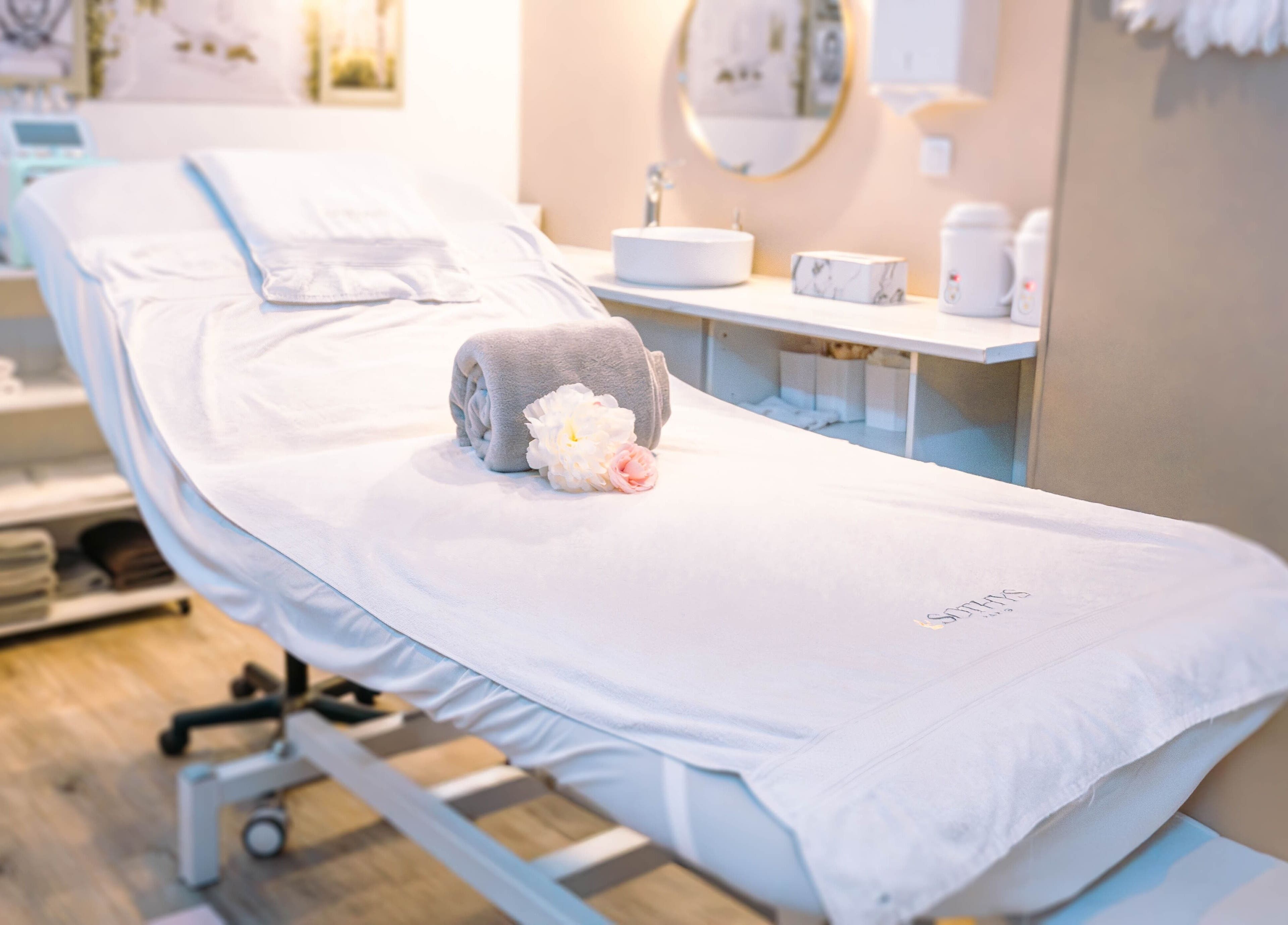 Table de soin relaxante à Beauté Antigone, Montpellier, Occitanie, FR, avec serviette et fleurs.