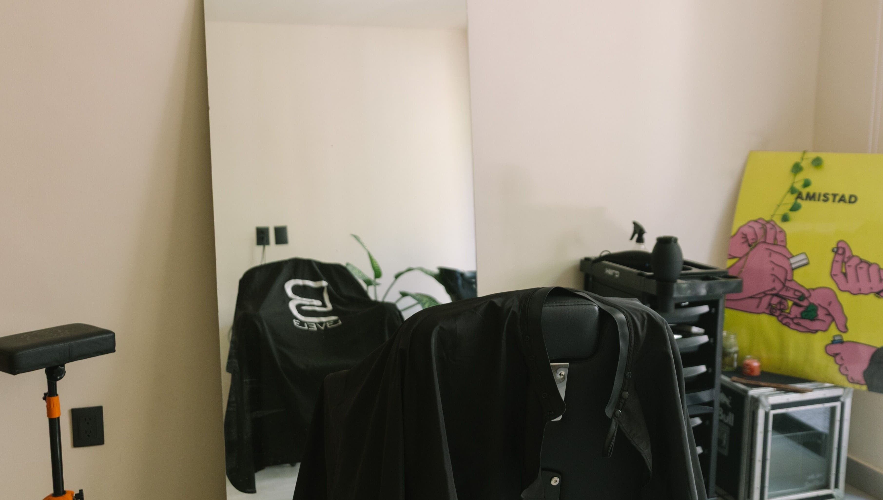 Minimalist salon station at nŌta studio, Tulum, Quintana Roo, MX with a stylish chair and vibrant art.