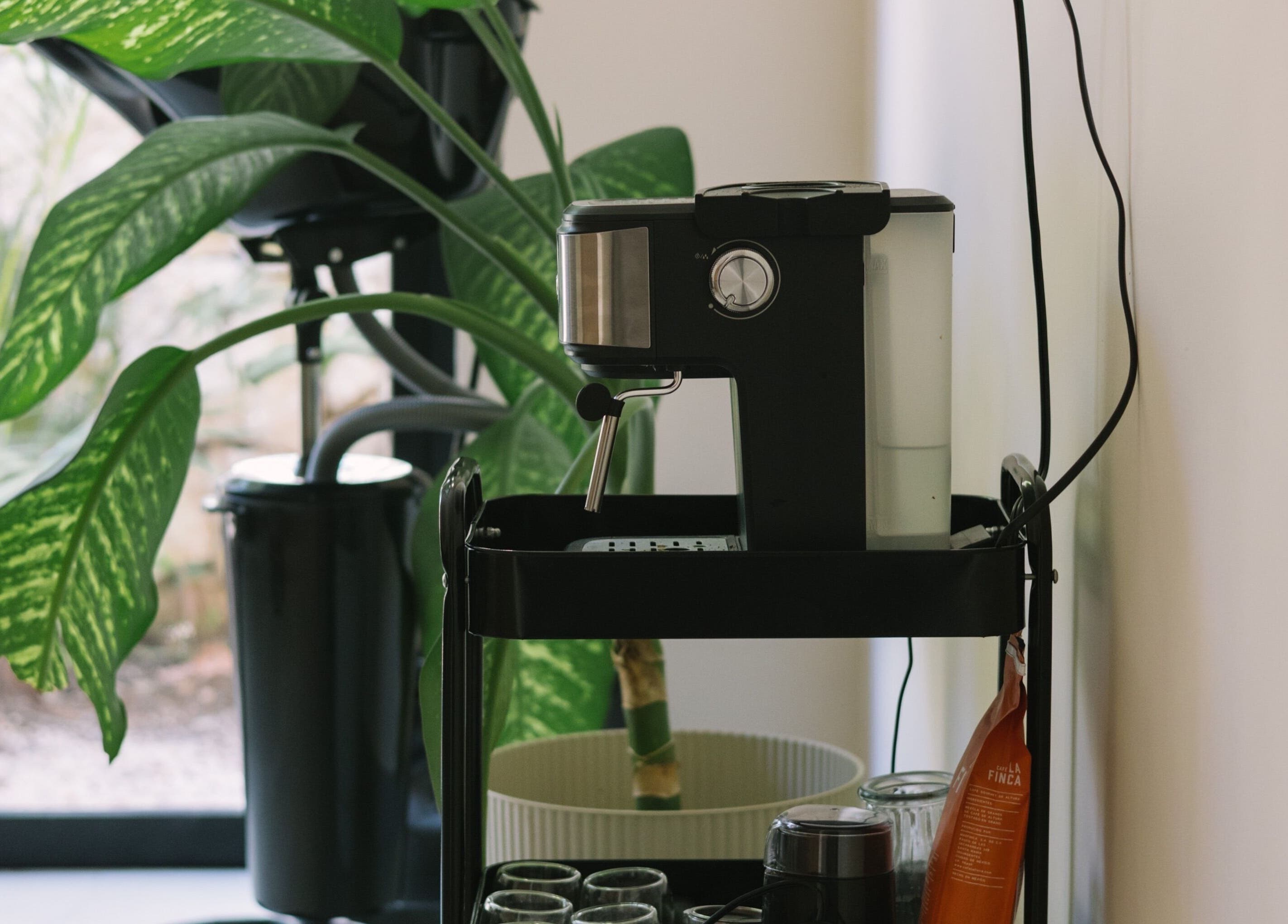 A sleek coffee maker beside lush greenery at nŌta studio, Tulum, Quintana Roo, MX.