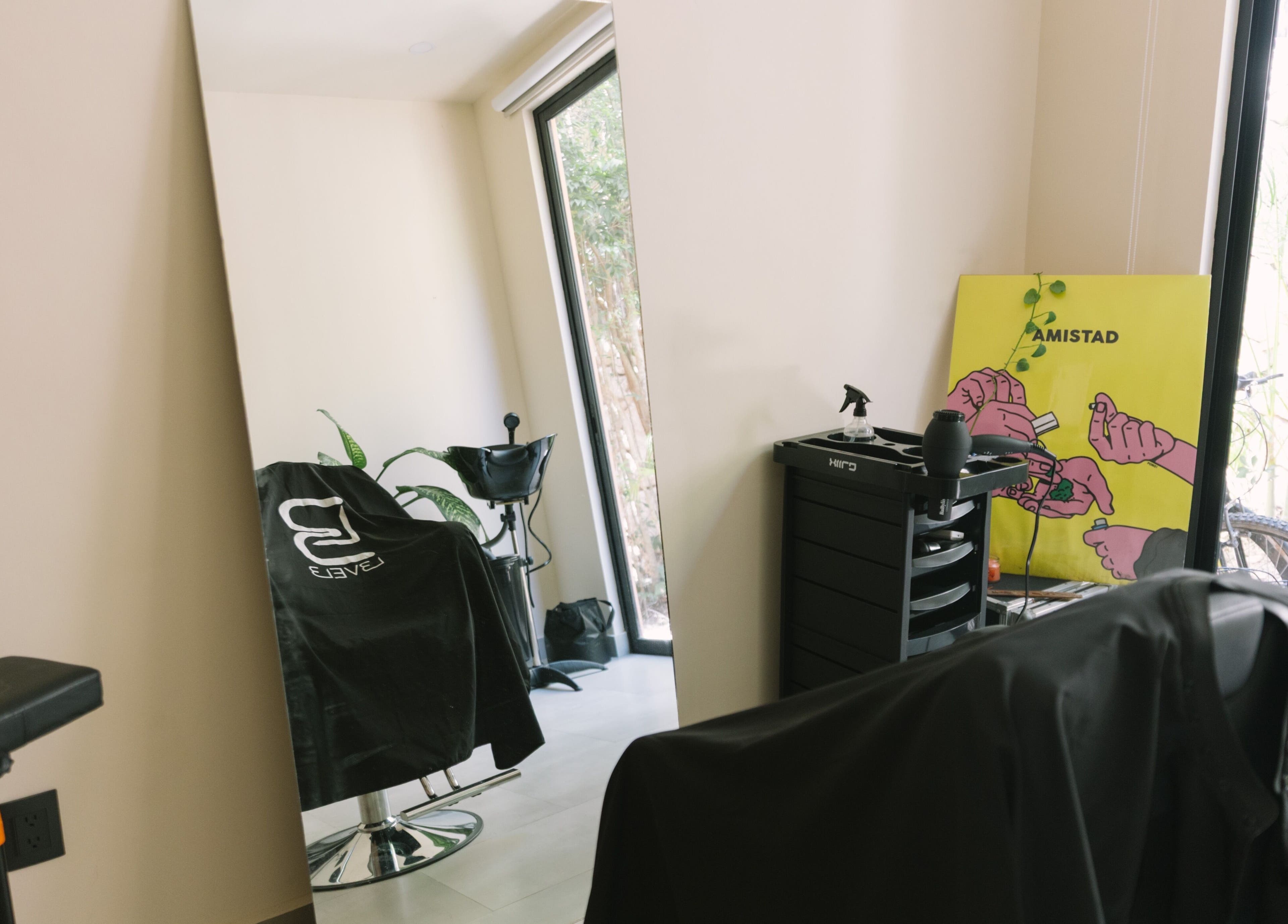 Modern salon interior at nŌta studio, Tulum, Quintana Roo, MX, featuring stylish chairs and vibrant decor.