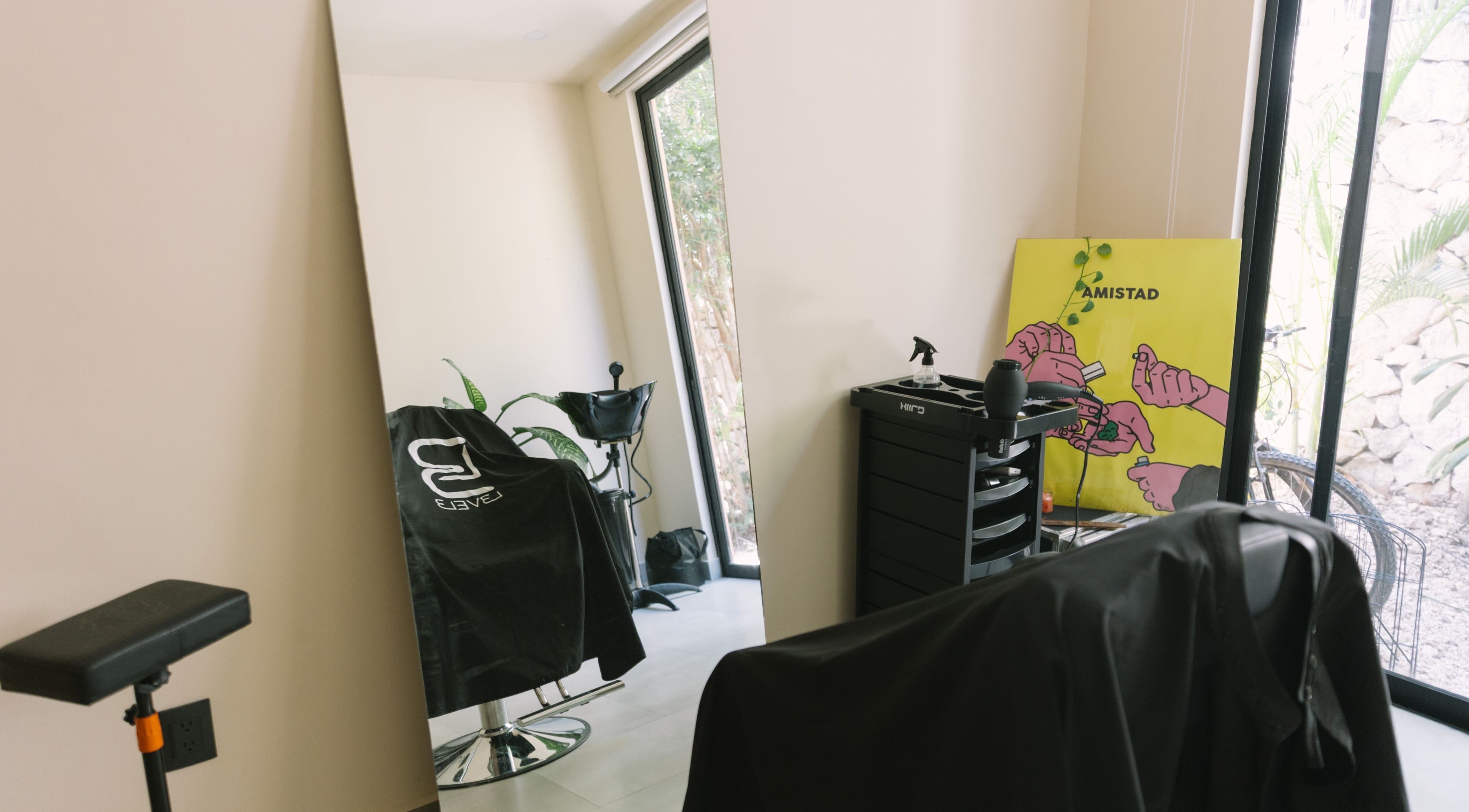 Modern salon interior at nŌta studio, Tulum, Quintana Roo, MX, featuring stylish chairs and vibrant decor.