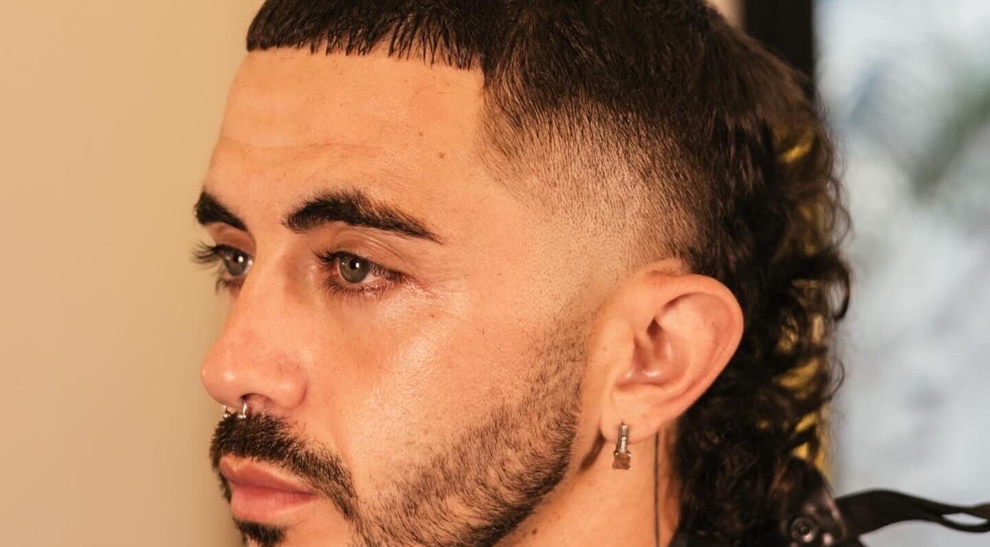 Side profile of a man with a stylish mullet haircut at nŌta studio, Tulum, Quintana Roo, MX.