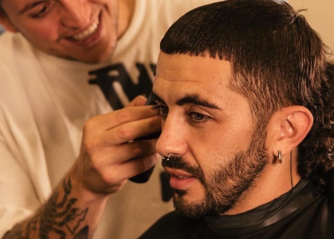 Modern haircut at nŌta studio, Tulum, Quintana Roo, MX. A barber styles a man's hair with precision.