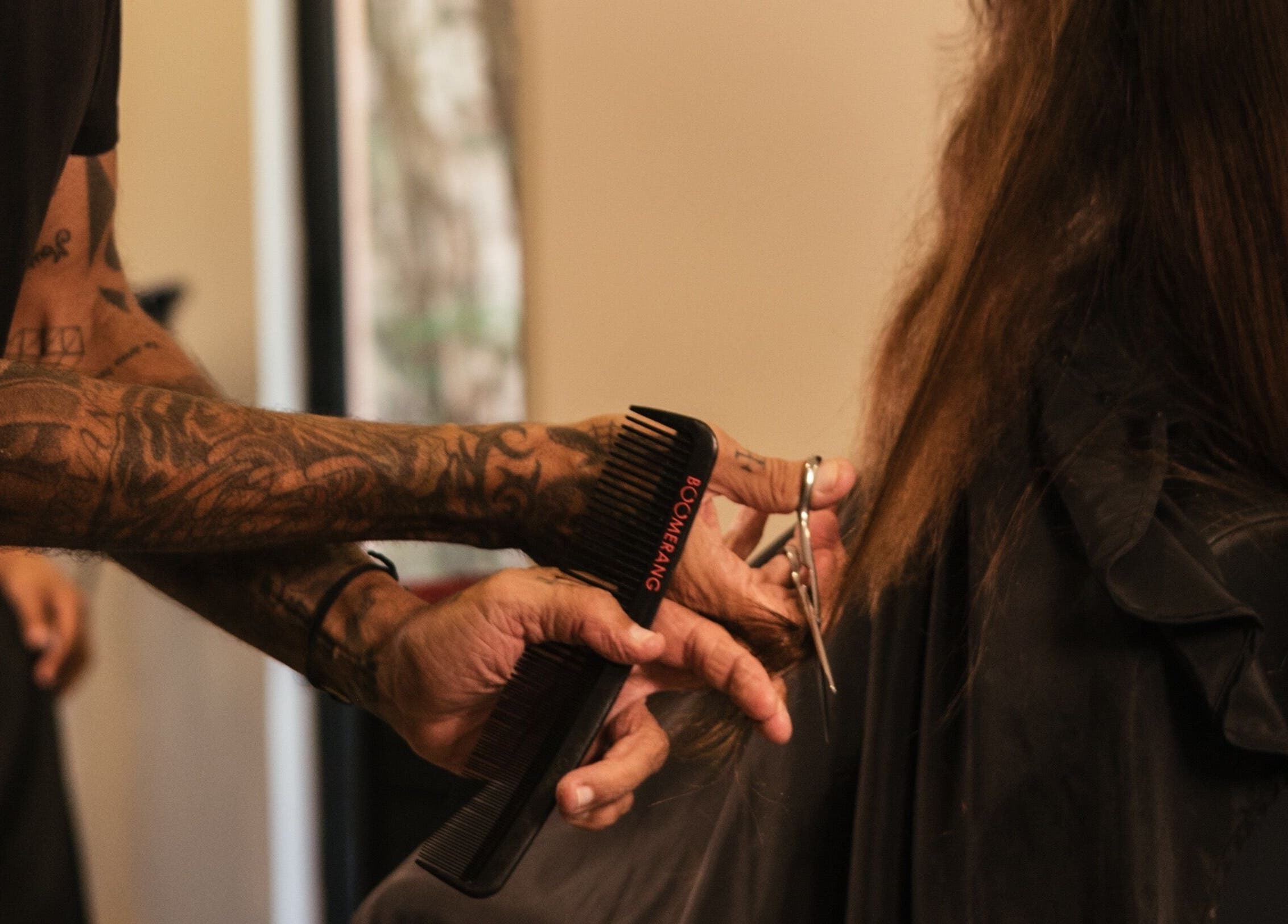 Stylist cutting hair at nŌta studio, Tulum, Quintana Roo, MX, showcasing expert grooming services.