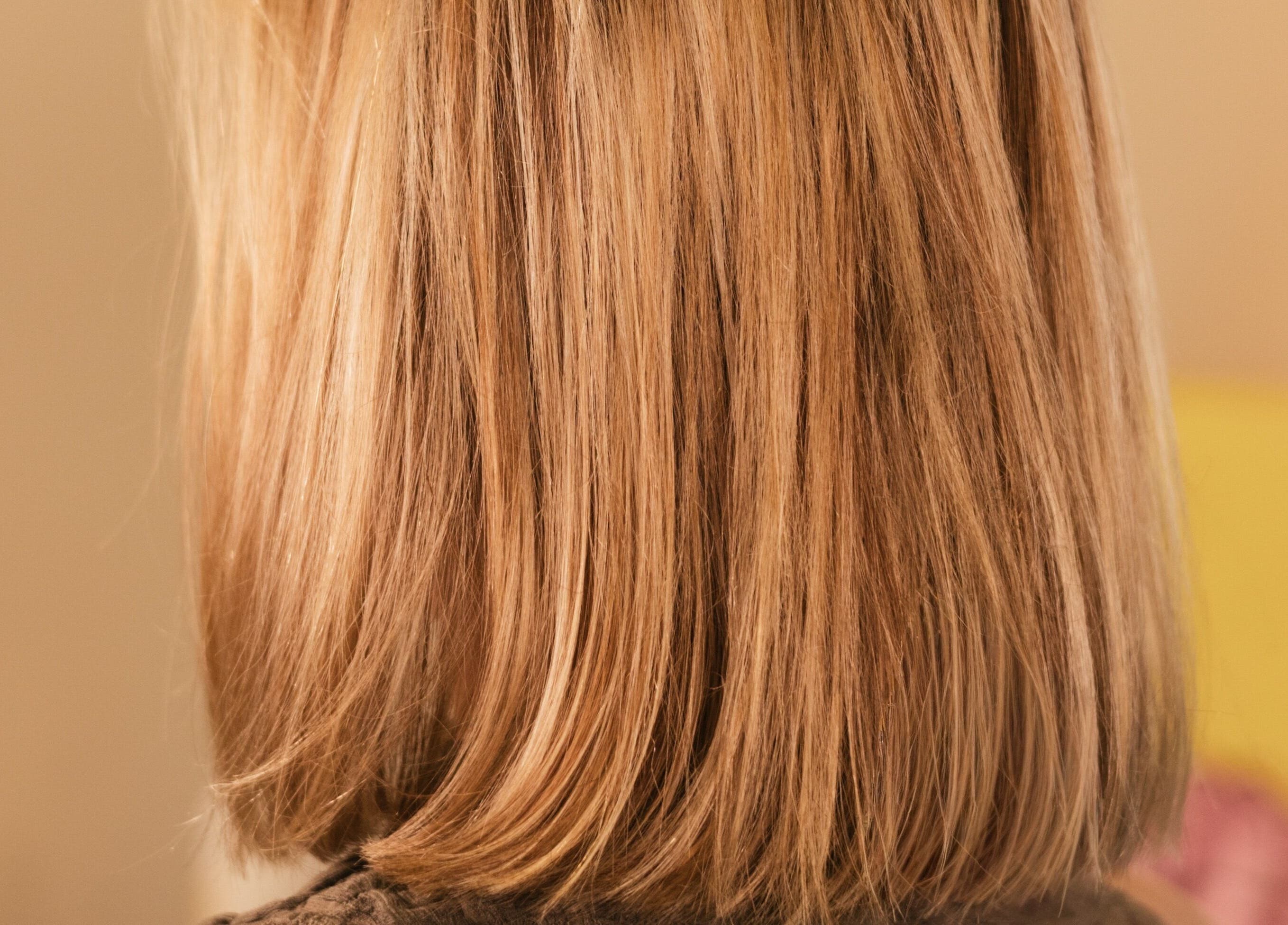 Back view of styled blonde hair at nŌta studio, Tulum, Quintana Roo, MX, showcasing elegance and shine.