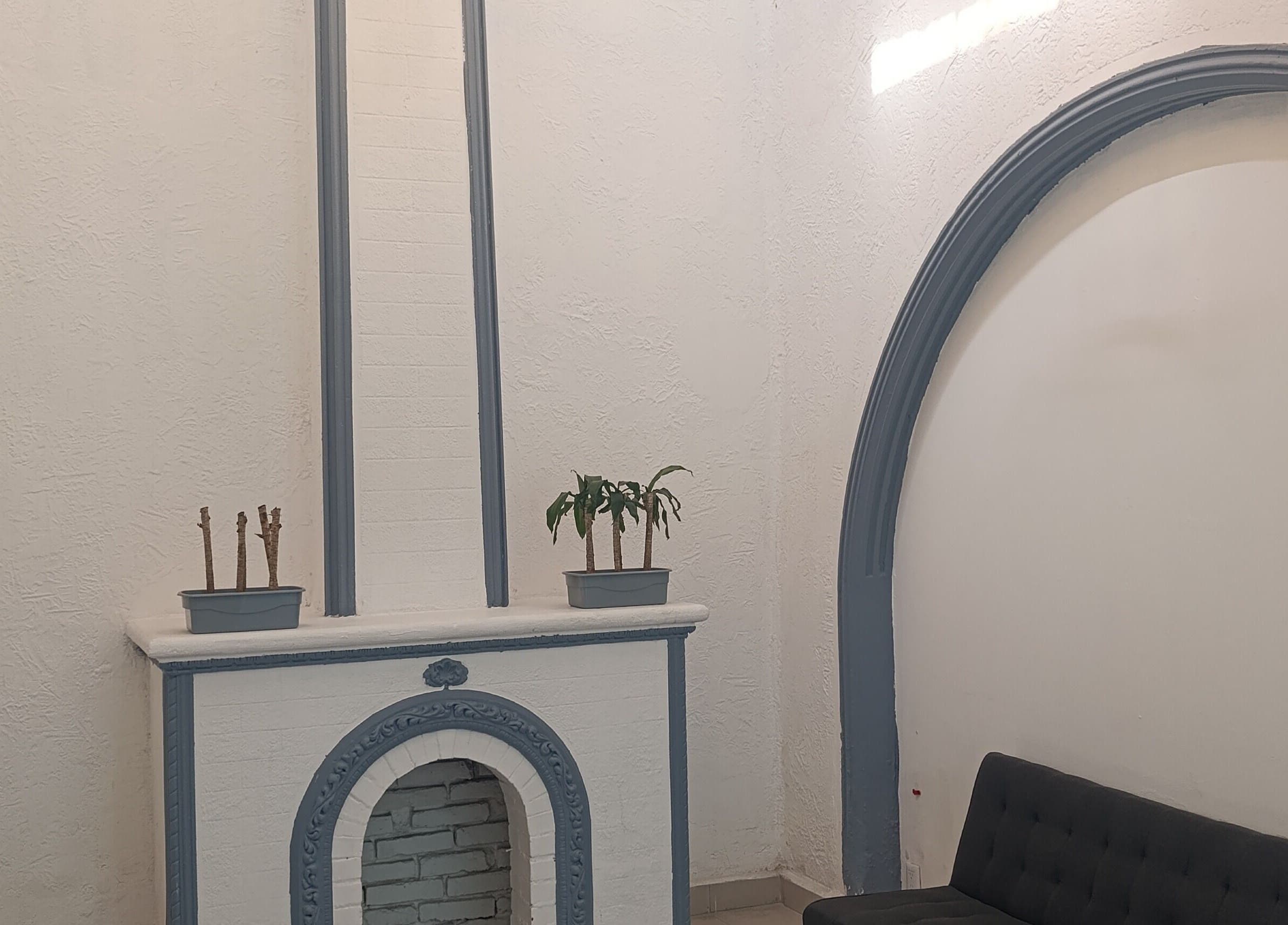 Chimenea elegante en The Room Barber Studio, Ciudad De México, MX. Decoración minimalista con plantas.
