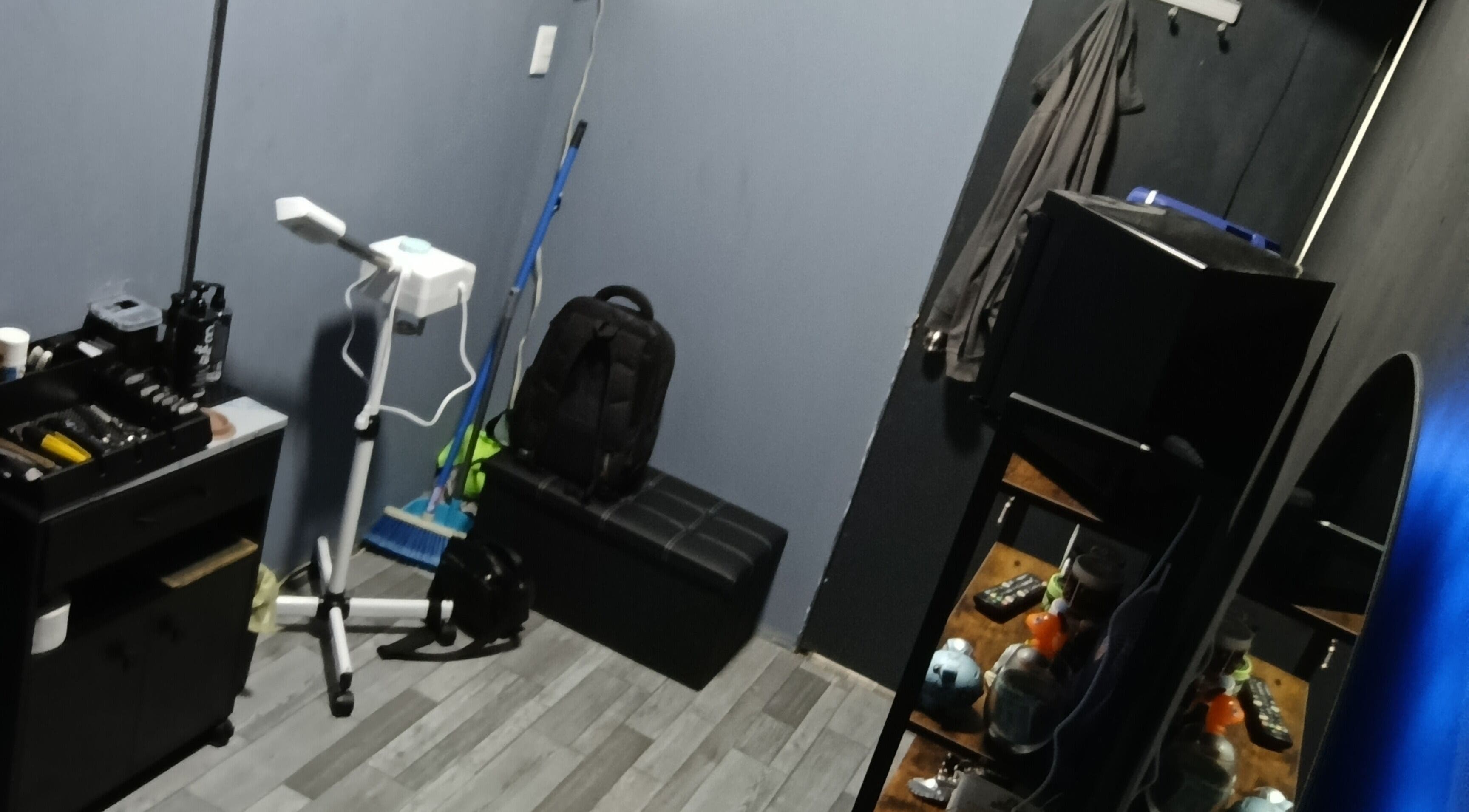 Espacio de trabajo en The Room Barber Studio, Ciudad De México, MX, con muebles y herramientas de estilismo.