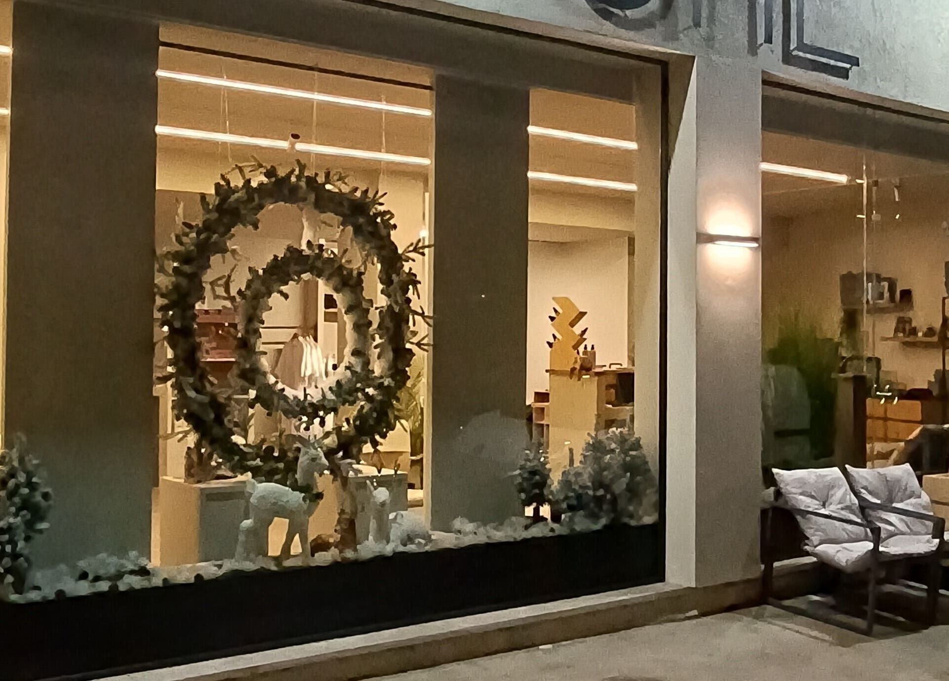 Η βραδινή πρόσοψη του 'She Beautiful Hair Only', Βόλος, Ελλαδα, GR, φωτισμένη με κομψά στεφάνια.