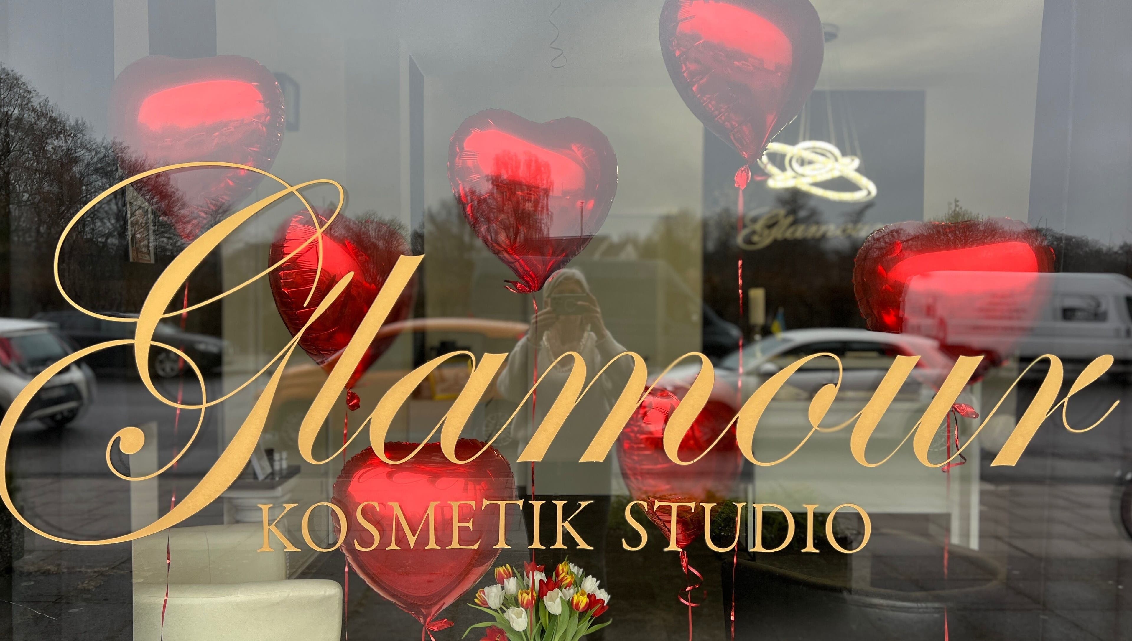 Schaufenster des Glamour Kosmetikstudio in Bielefeld mit roten Herzballons und Blumen.