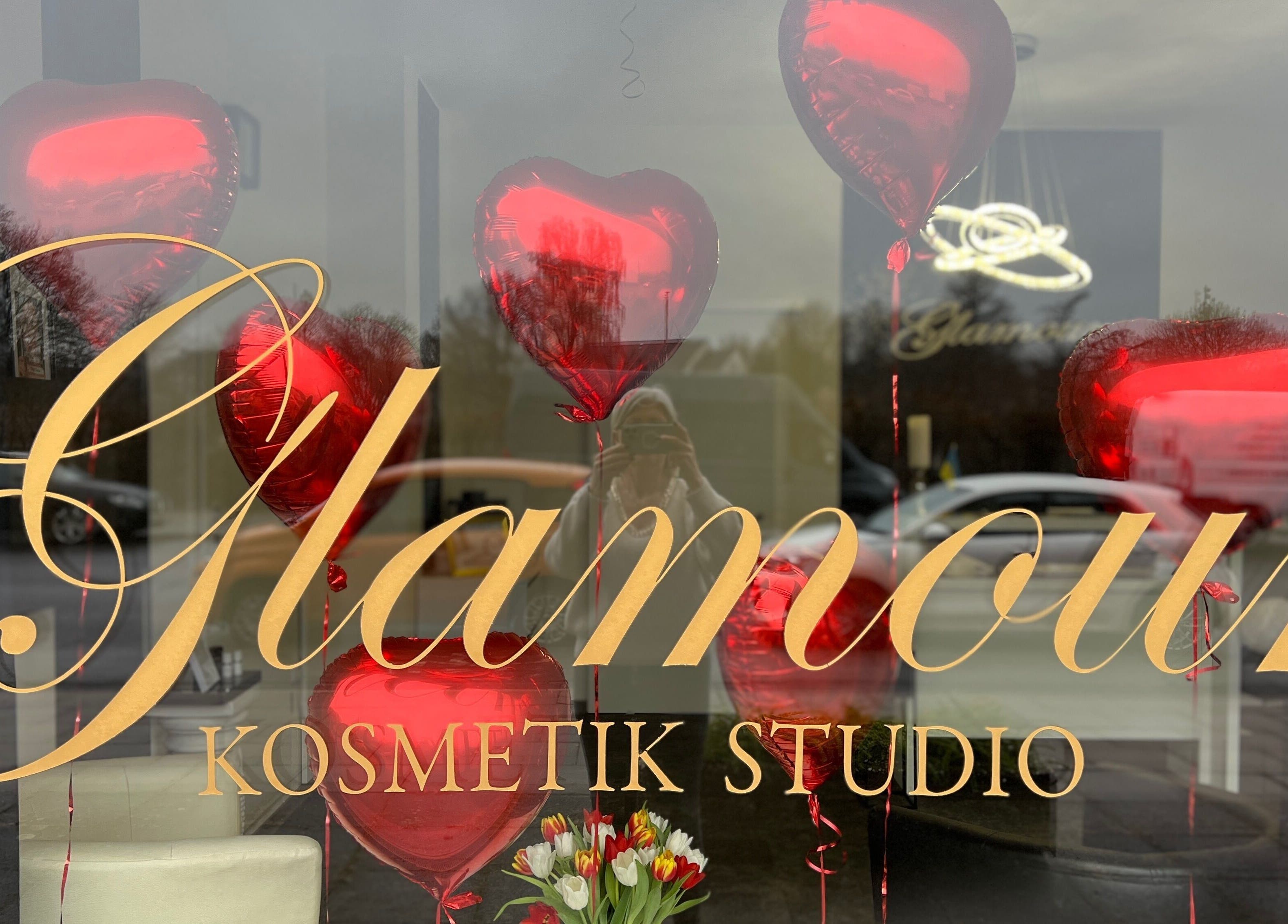 Schaufenster des Glamour Kosmetikstudio in Bielefeld mit roten Herzballons und Blumen.