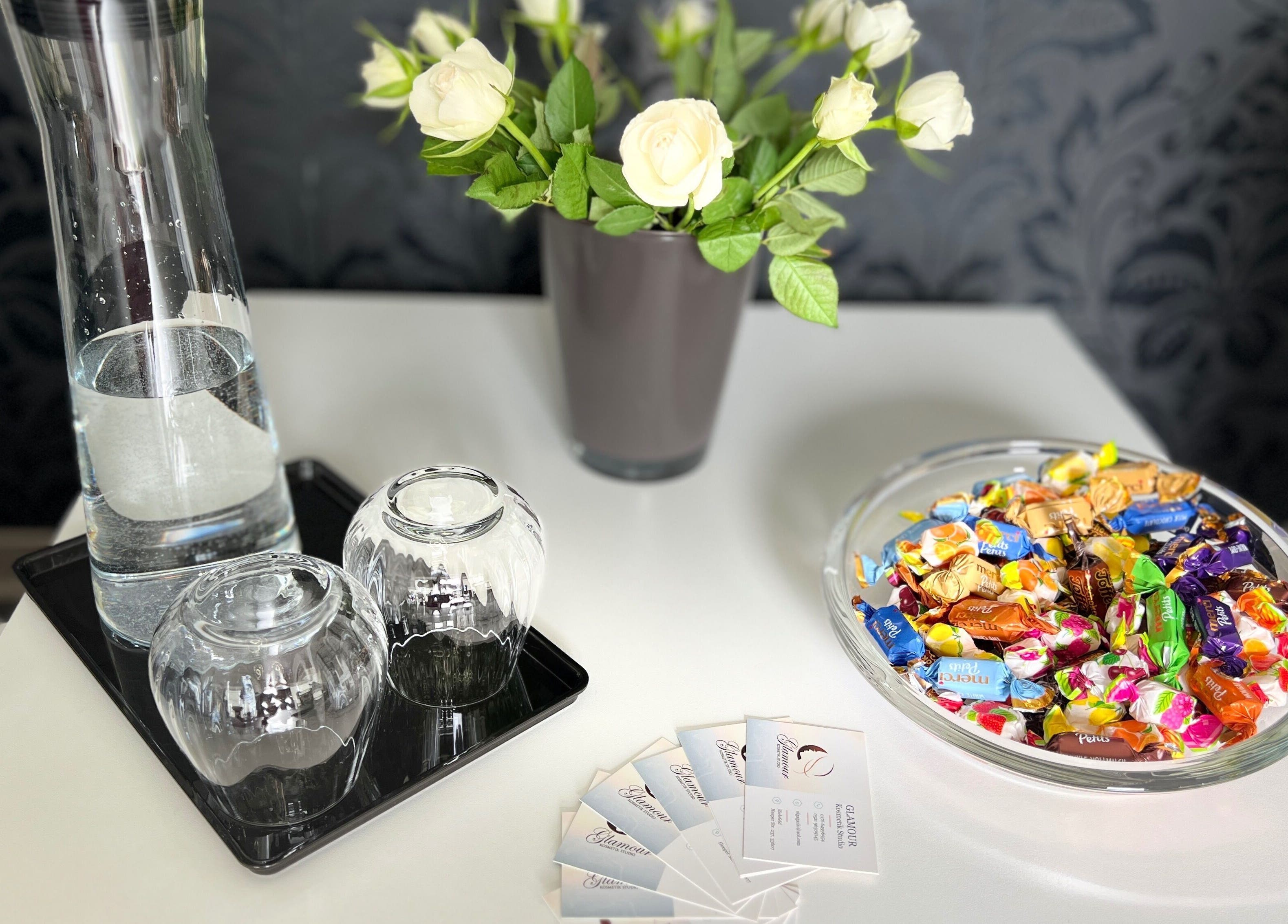 Empfangsbereich im Glamour Kosmetikstudio, Bielefeld, Nordrhein-westfalen, DE, mit Vase, Süßigkeiten und Wasser.