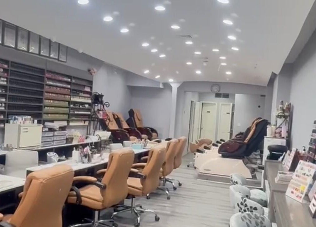 Interior of Meiko Nail Spa in New York, New York, US featuring plush chairs and nail polish displays.