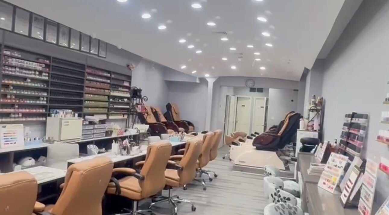 Interior of Meiko Nail Spa in New York, New York, US featuring plush chairs and nail polish displays.
