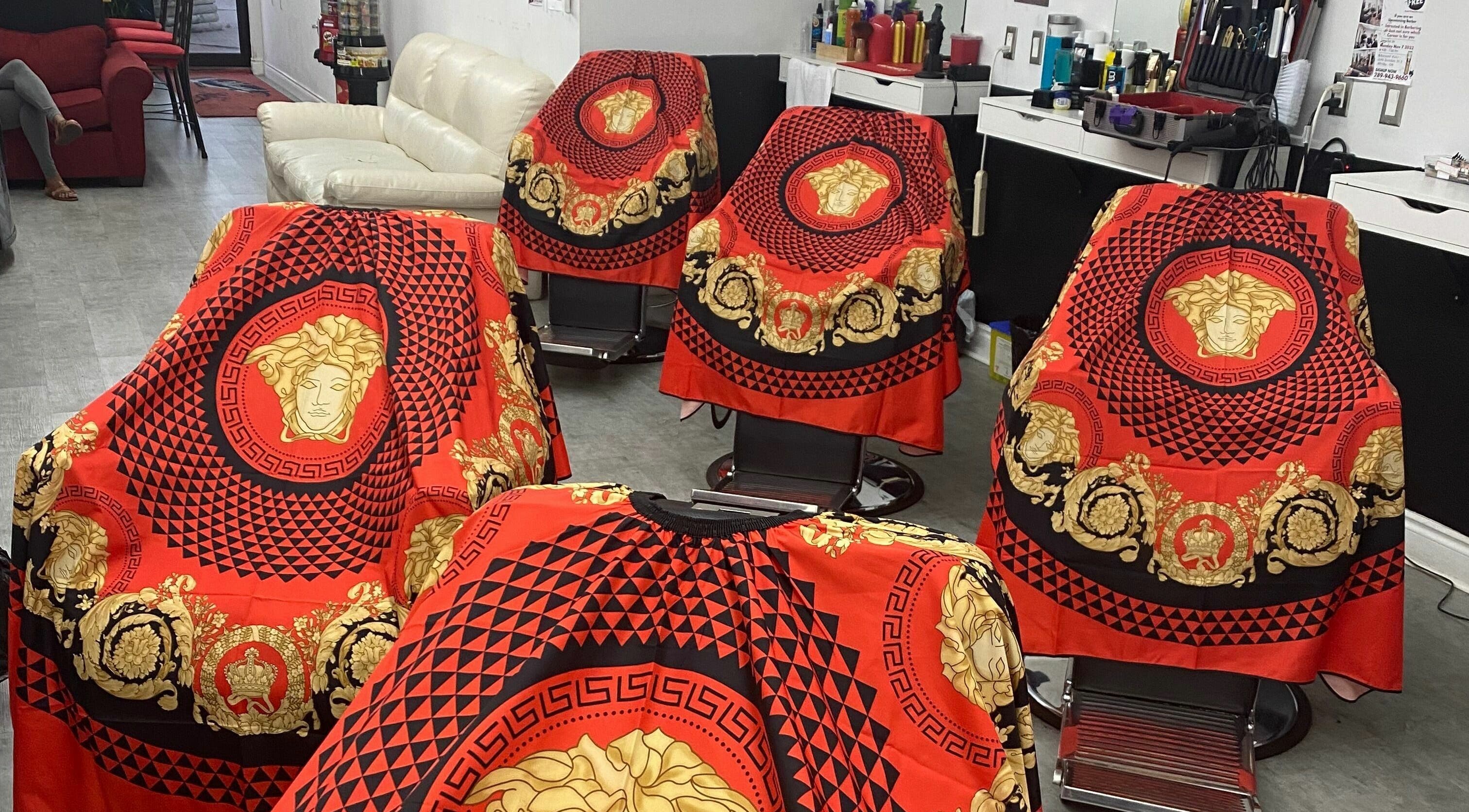 Luxurious red and gold styling capes at Blessed Kutz, Whitby, Ontario, CA, showcasing elegance and style.