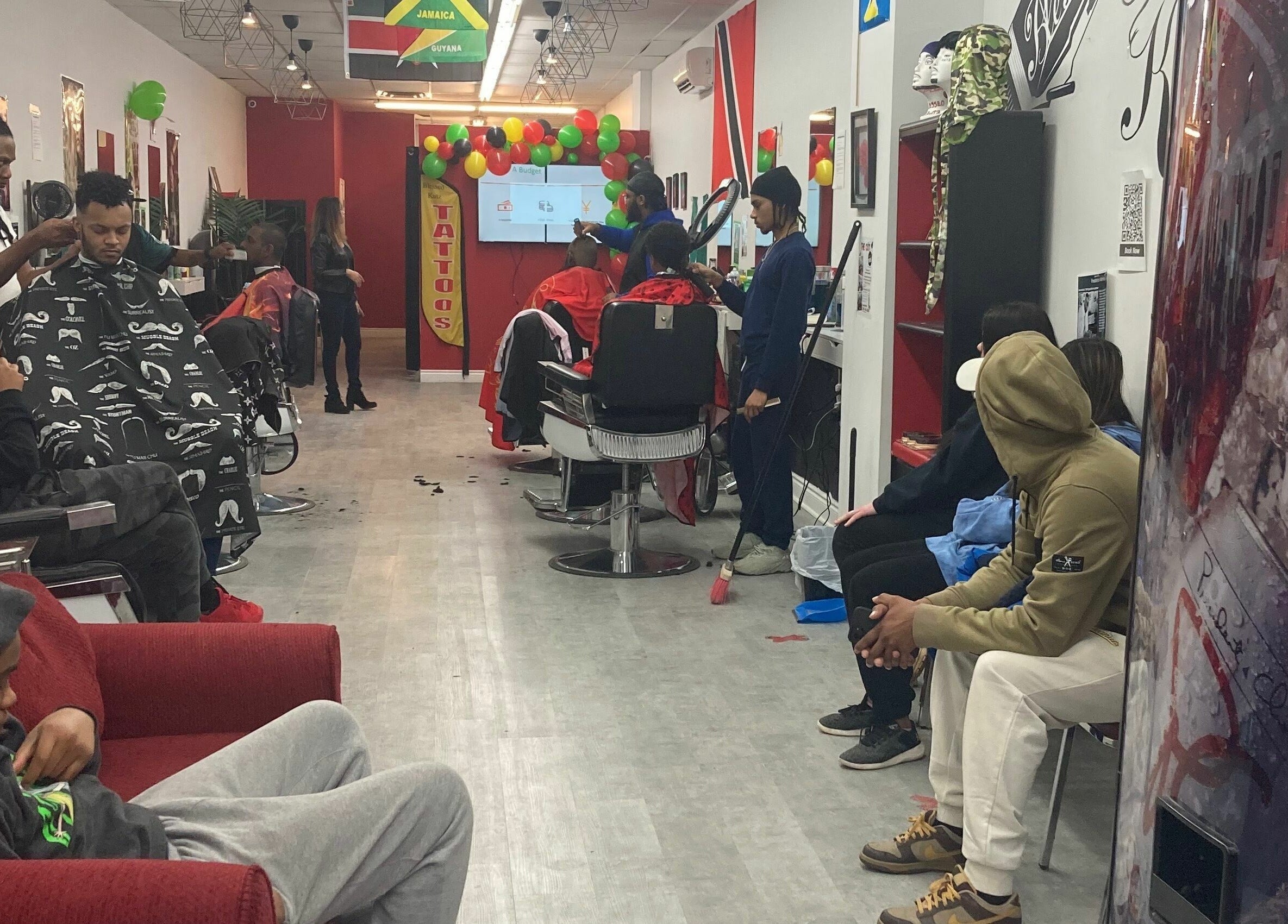 Guests enjoying haircuts at Blessed Kutz in Whitby, Ontario, CA, showcasing a lively salon atmosphere.