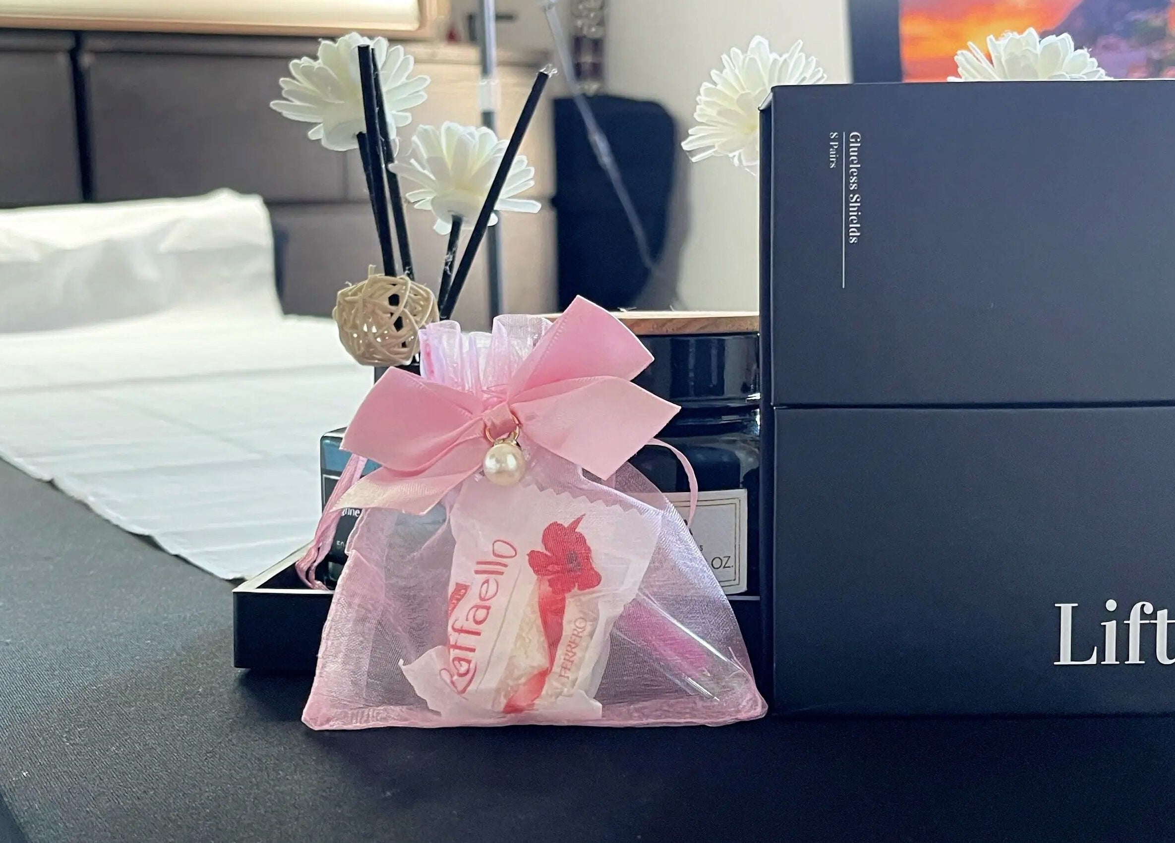 Elegant spa setting at Lash Lift & Brows London in London, England, GB with a pink gift bag and ambient decor.