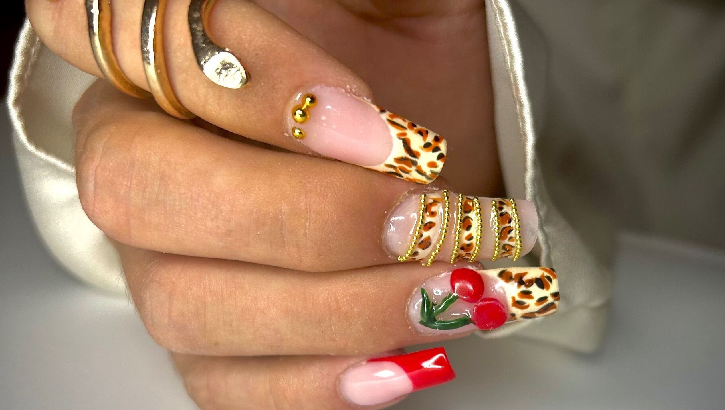 Manucure élégante avec motifs léopard et cerise chez Nail By Kika, Bayonne, Nouvelle-Aquitaine, FR.