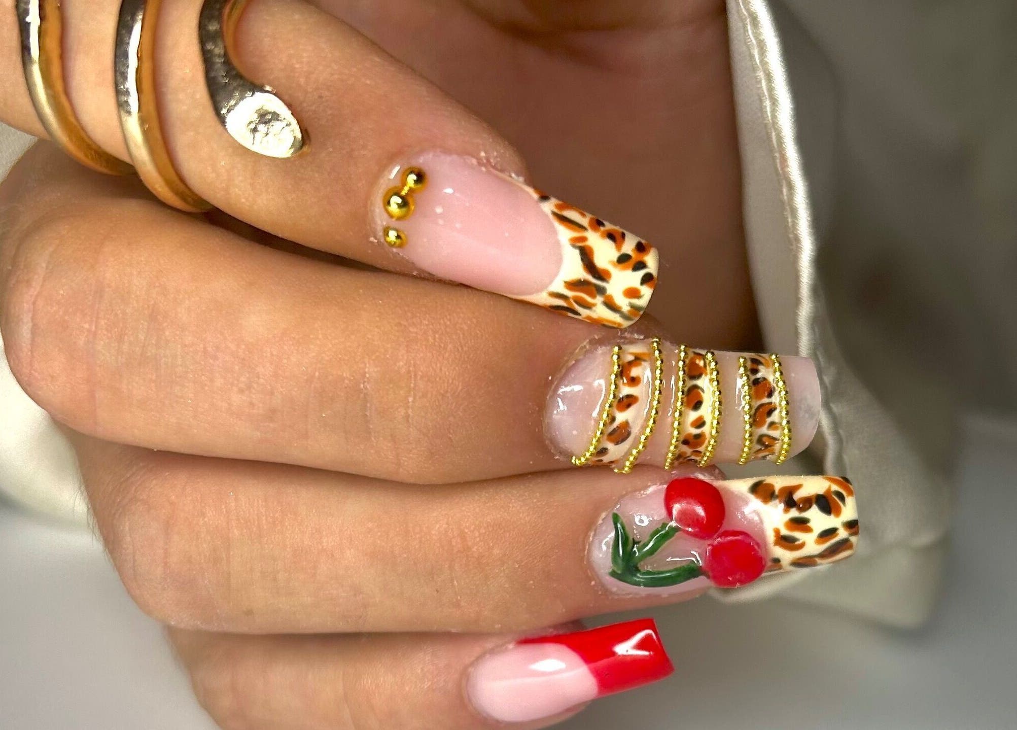 Manucure élégante avec motifs léopard et cerise chez Nail By Kika, Bayonne, Nouvelle-Aquitaine, FR.