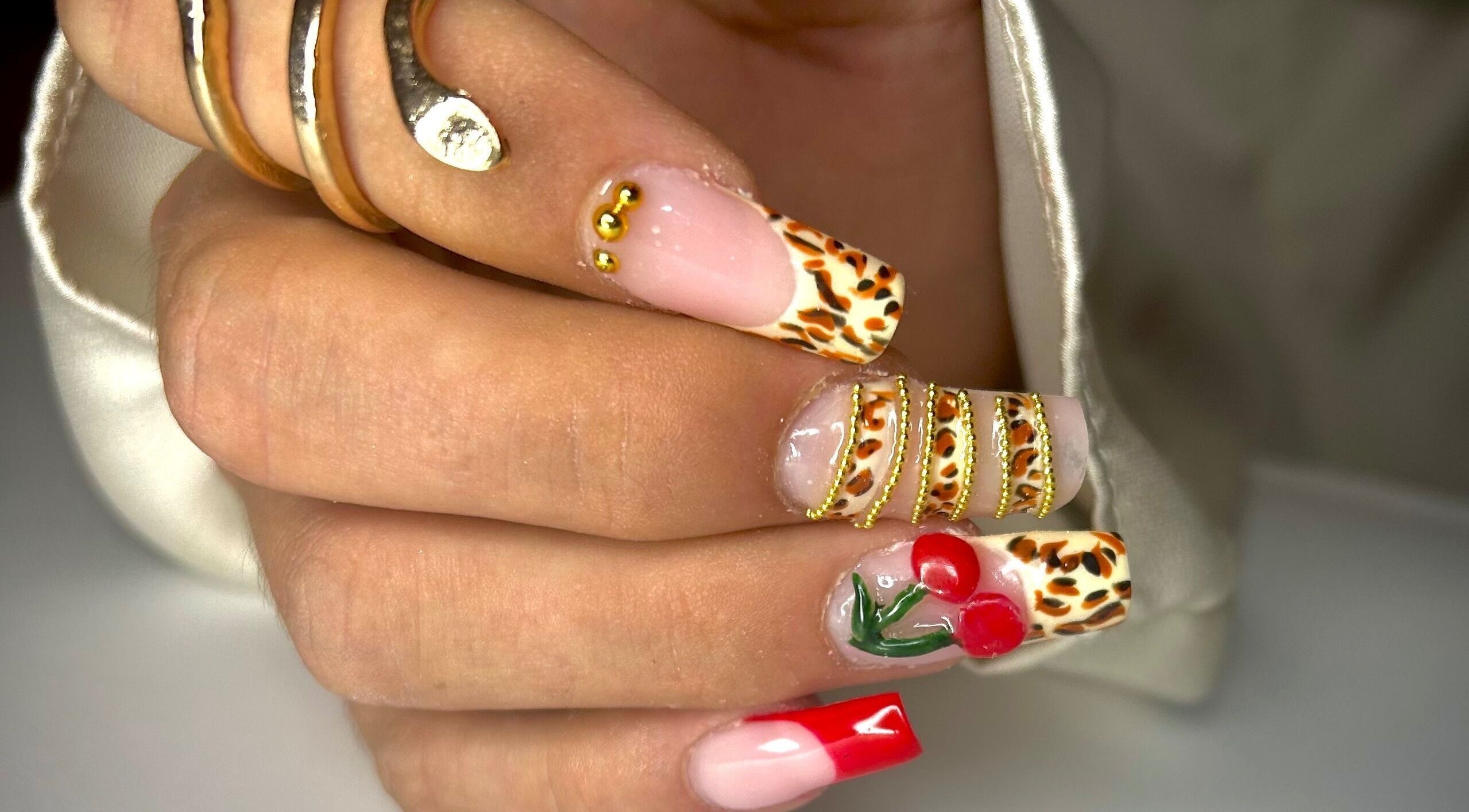 Manucure élégante avec motifs léopard et cerise chez Nail By Kika, Bayonne, Nouvelle-Aquitaine, FR.