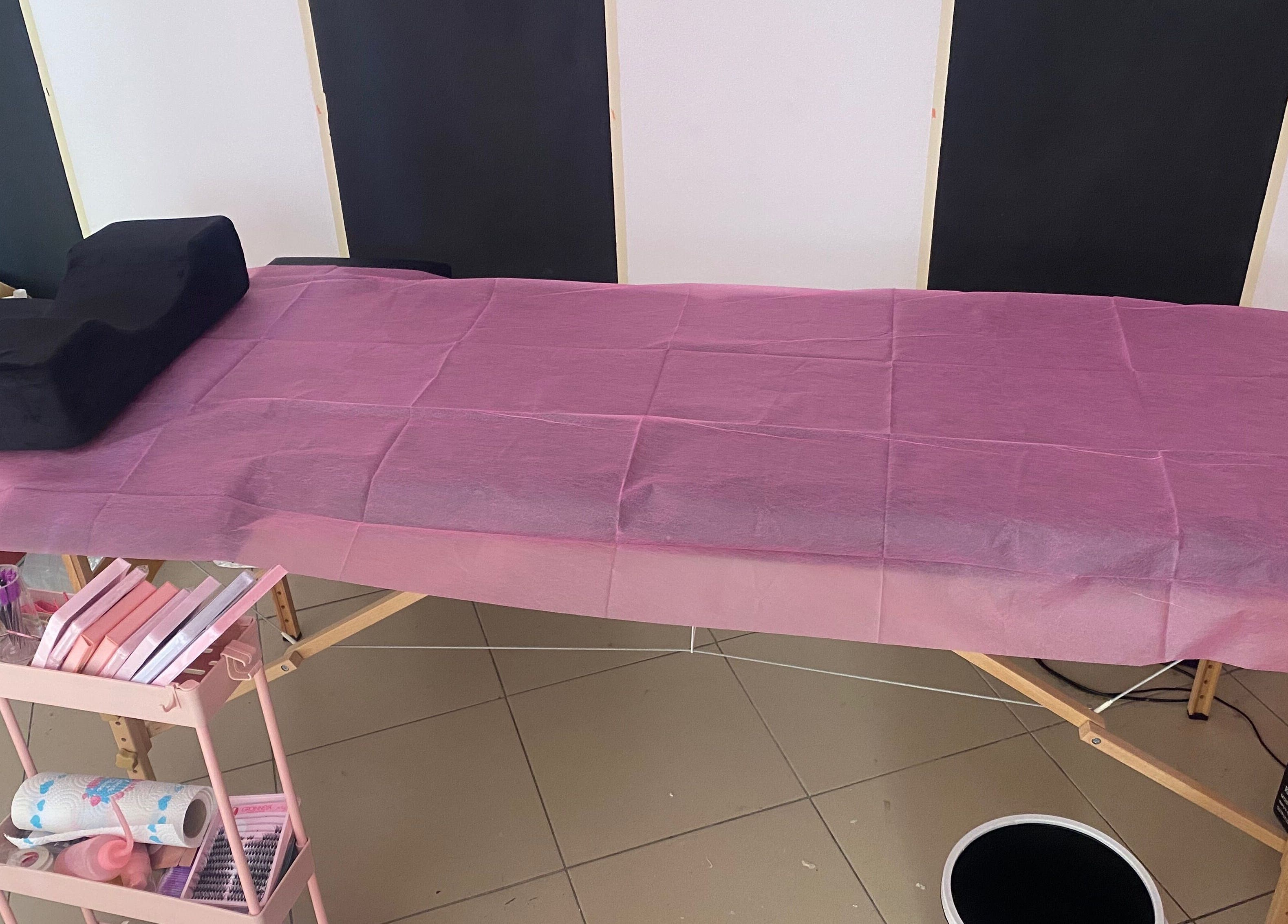 Treatment bed with pink sheet at DaintyLadies BeautySpot, Paramaribo, Paramaribo, SR, ready for wellness therapy.