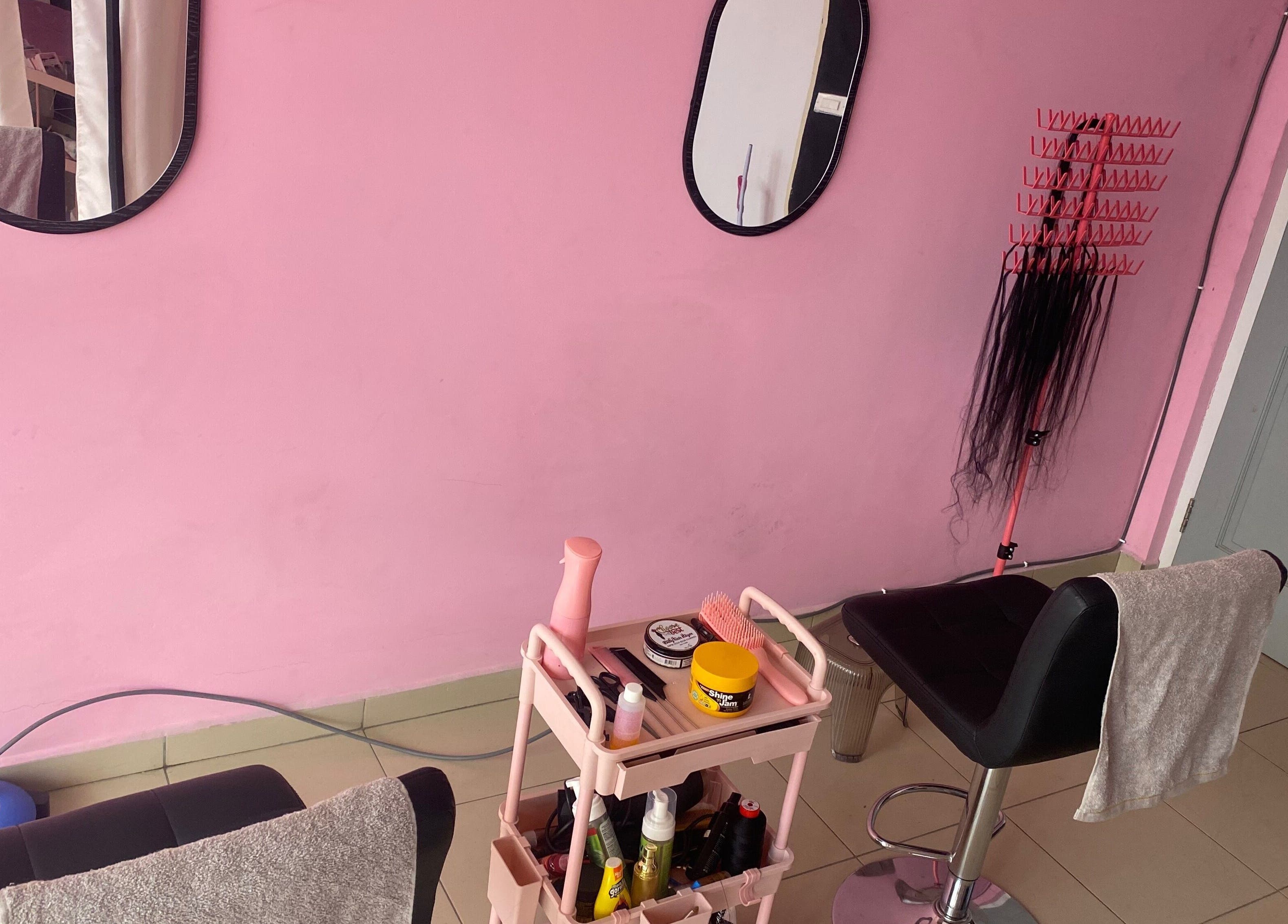 DaintyLadies BeautySpot salon in Paramaribo, SR showcasing a stylish pink interior and hair care tools.