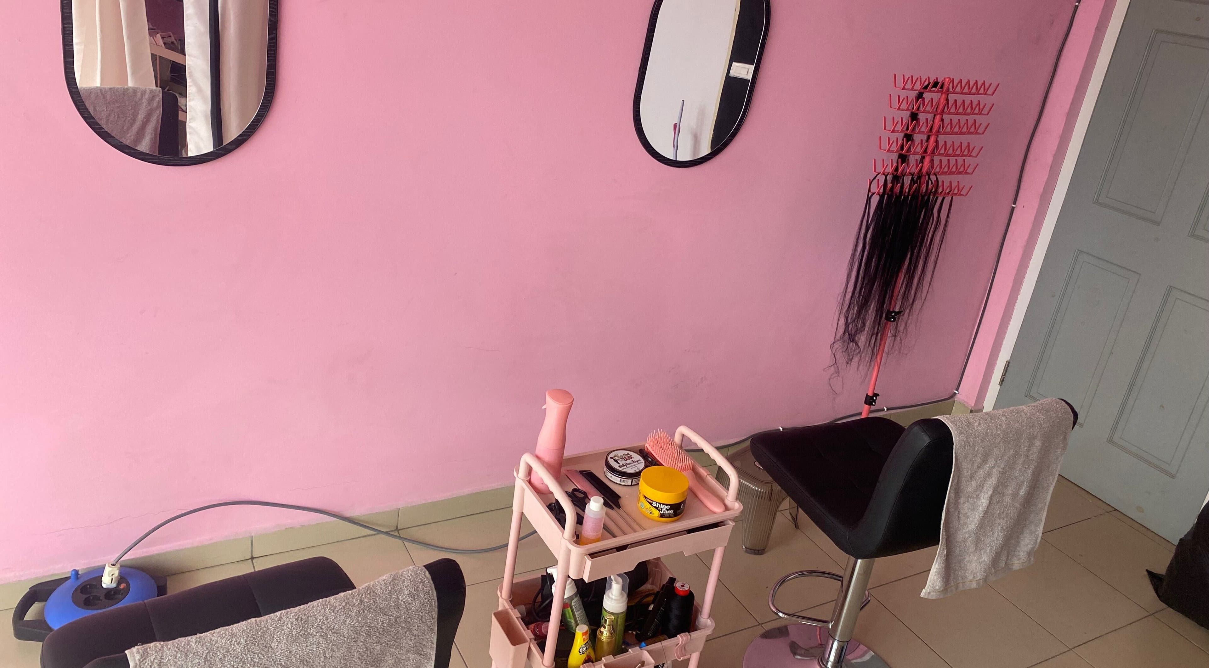 DaintyLadies BeautySpot salon in Paramaribo, SR showcasing a stylish pink interior and hair care tools.