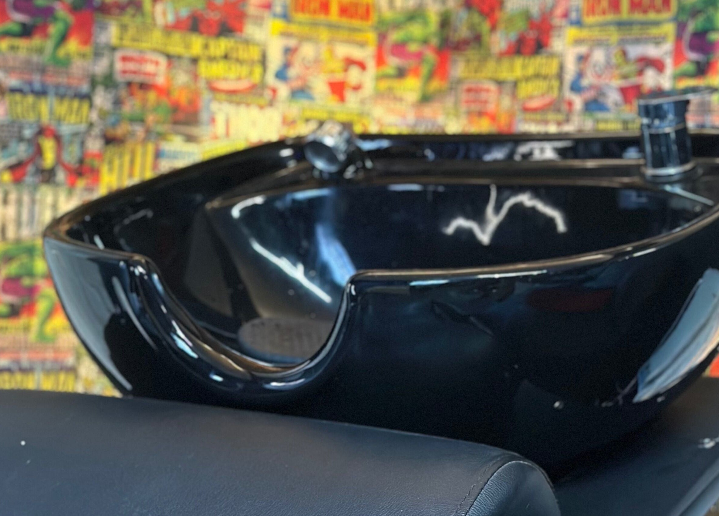 Trendy washbasin at Diego Barber Studio, San Pedro Las Huertas, Sacatepéquez, GT, with vibrant comic backdrop.