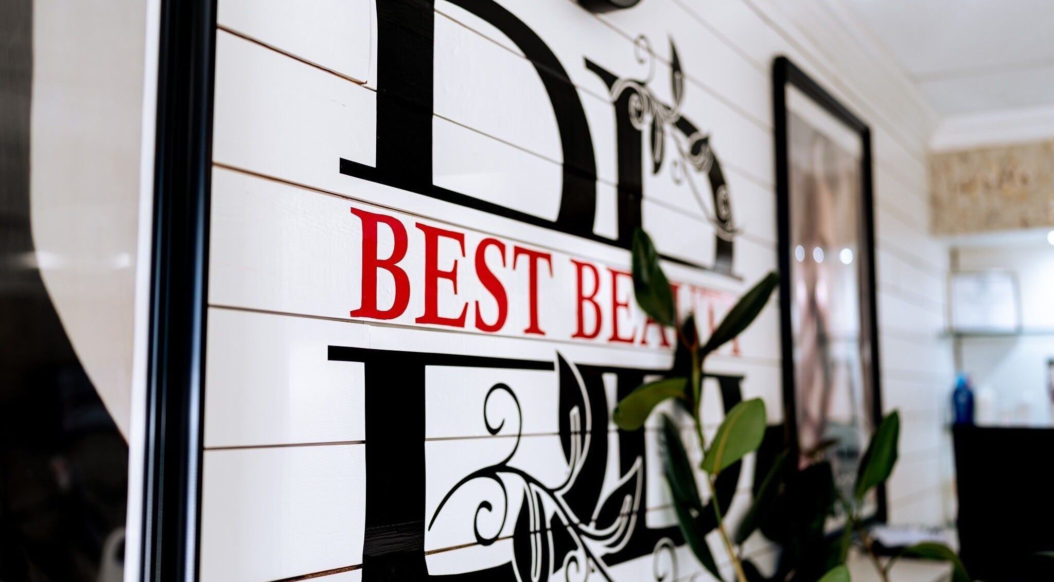 Bright 'Best Beauty Salon' sign with floral accents in Spring, Texas, US.