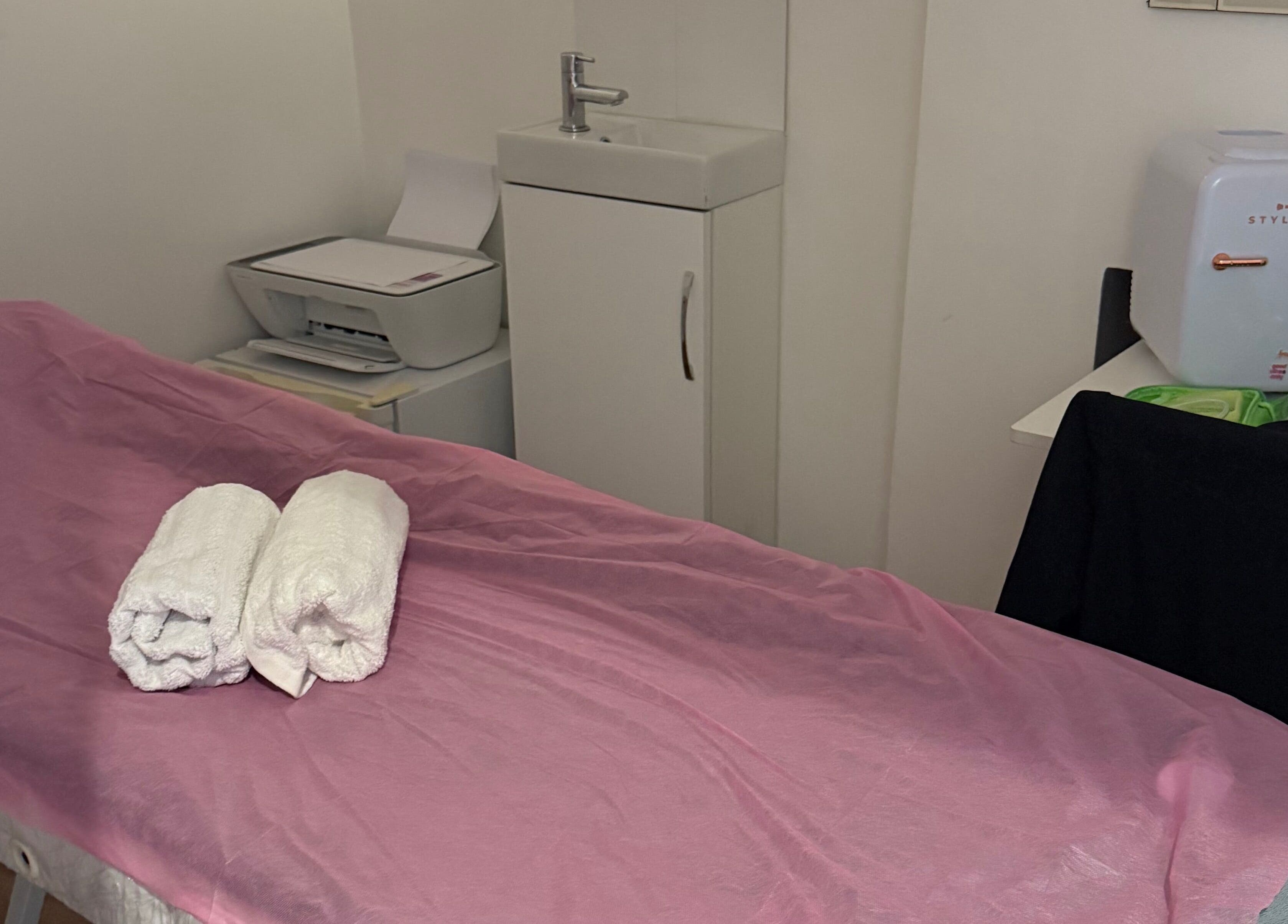 Sala de massagem na Paloma Chinelato massage therapy, Exeter, England, GB com toalhas em cama preparada.