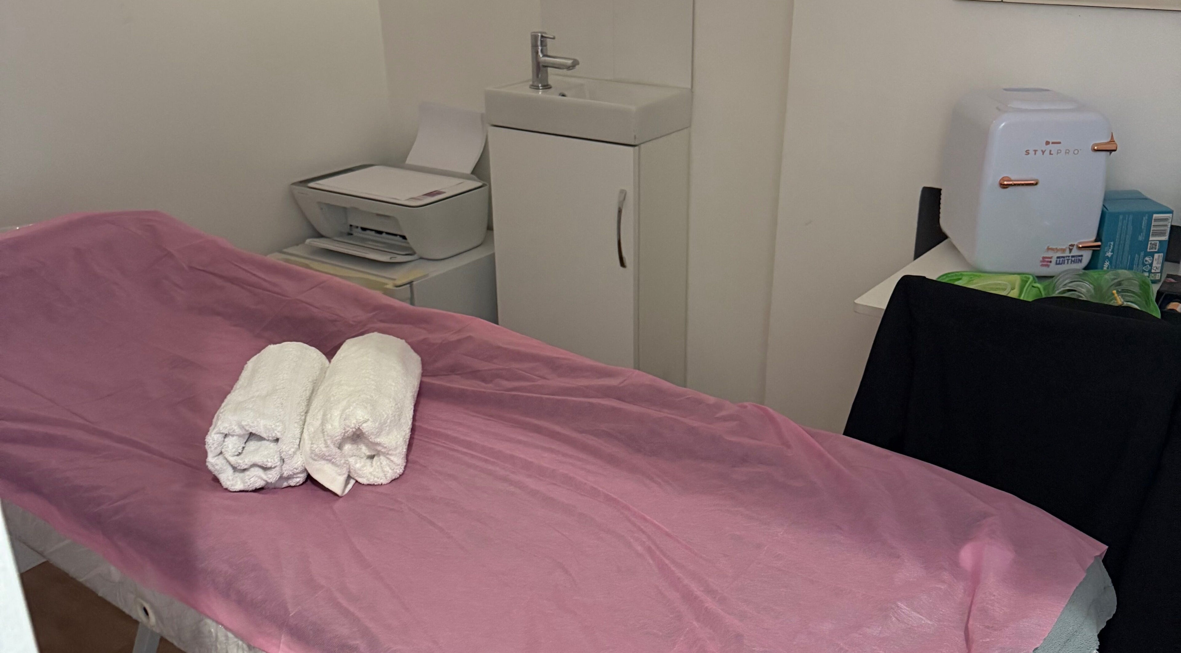 Sala de massagem na Paloma Chinelato massage therapy, Exeter, England, GB com toalhas em cama preparada.