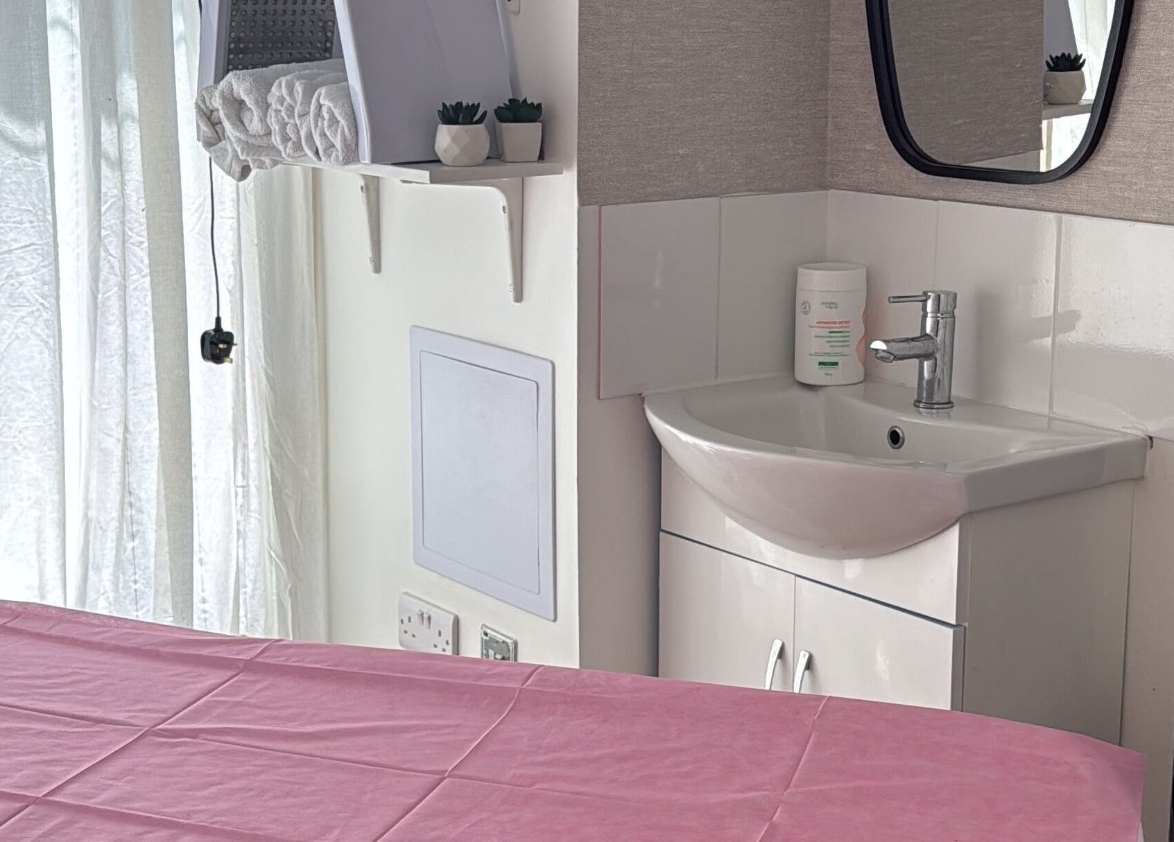 Sala de massagem em Paloma Chinelato, Exeter, England, GB, com mesa e pia.