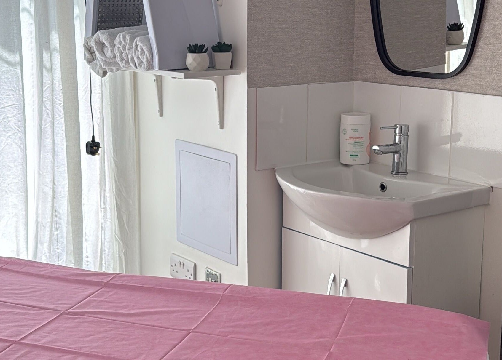 Sala de massagem em Paloma Chinelato, Exeter, England, GB, com mesa e pia.