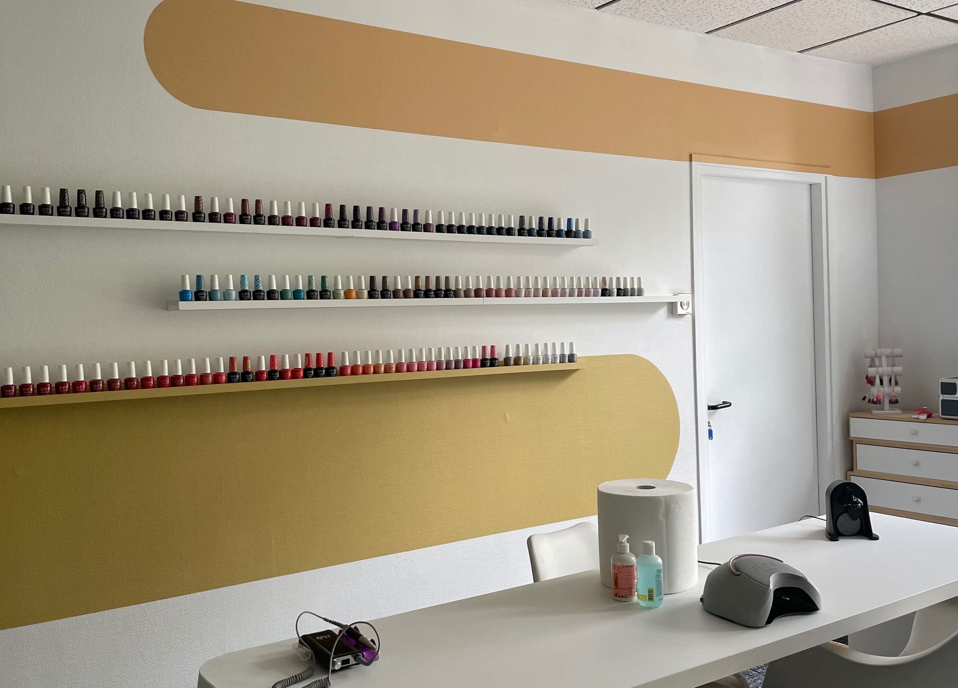 Espace manucure soigné à Zeste d’Amande, Saint André lez Lille, France, FR, avec étagères de vernis colorés.