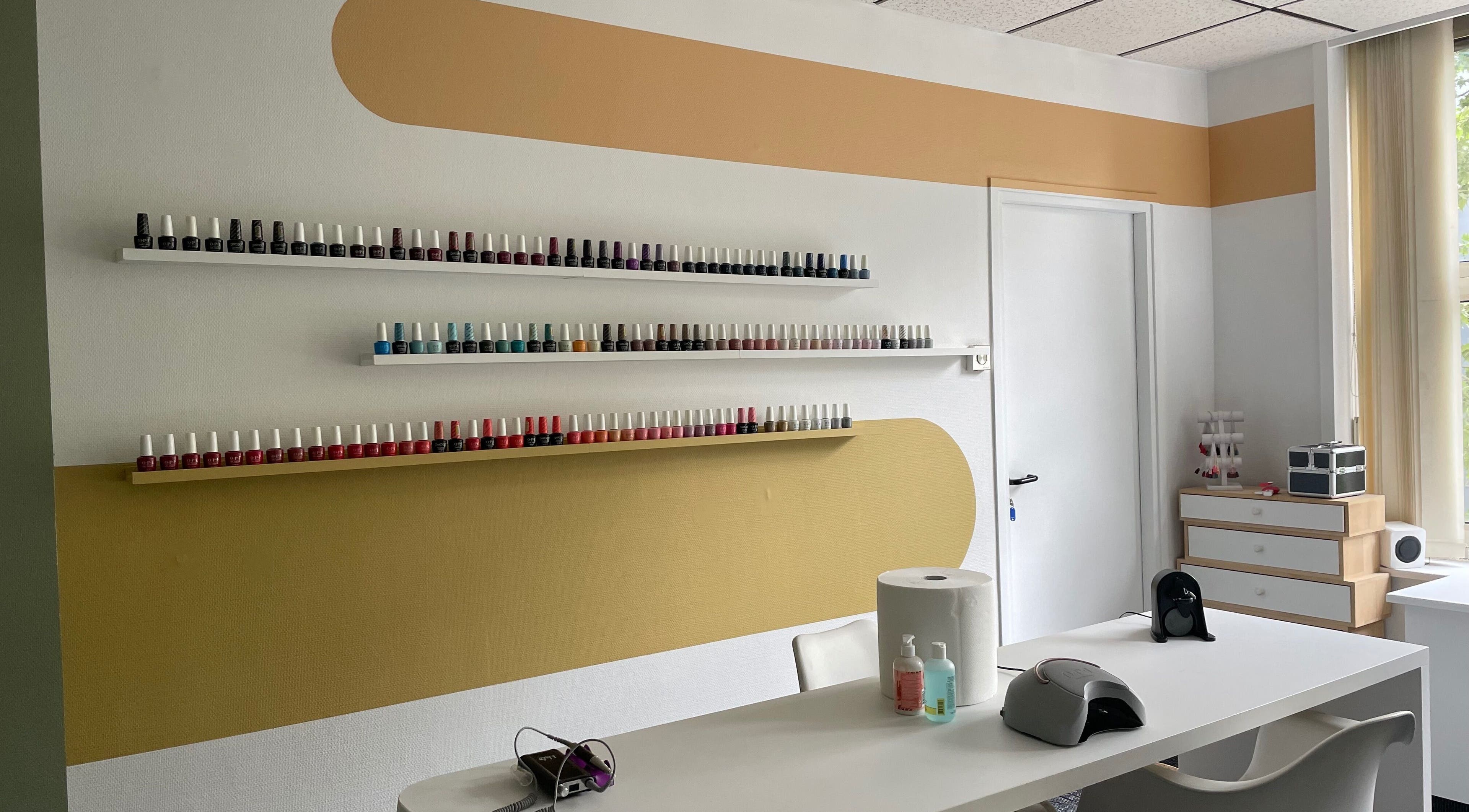 Espace manucure soigné à Zeste d’Amande, Saint André lez Lille, France, FR, avec étagères de vernis colorés.