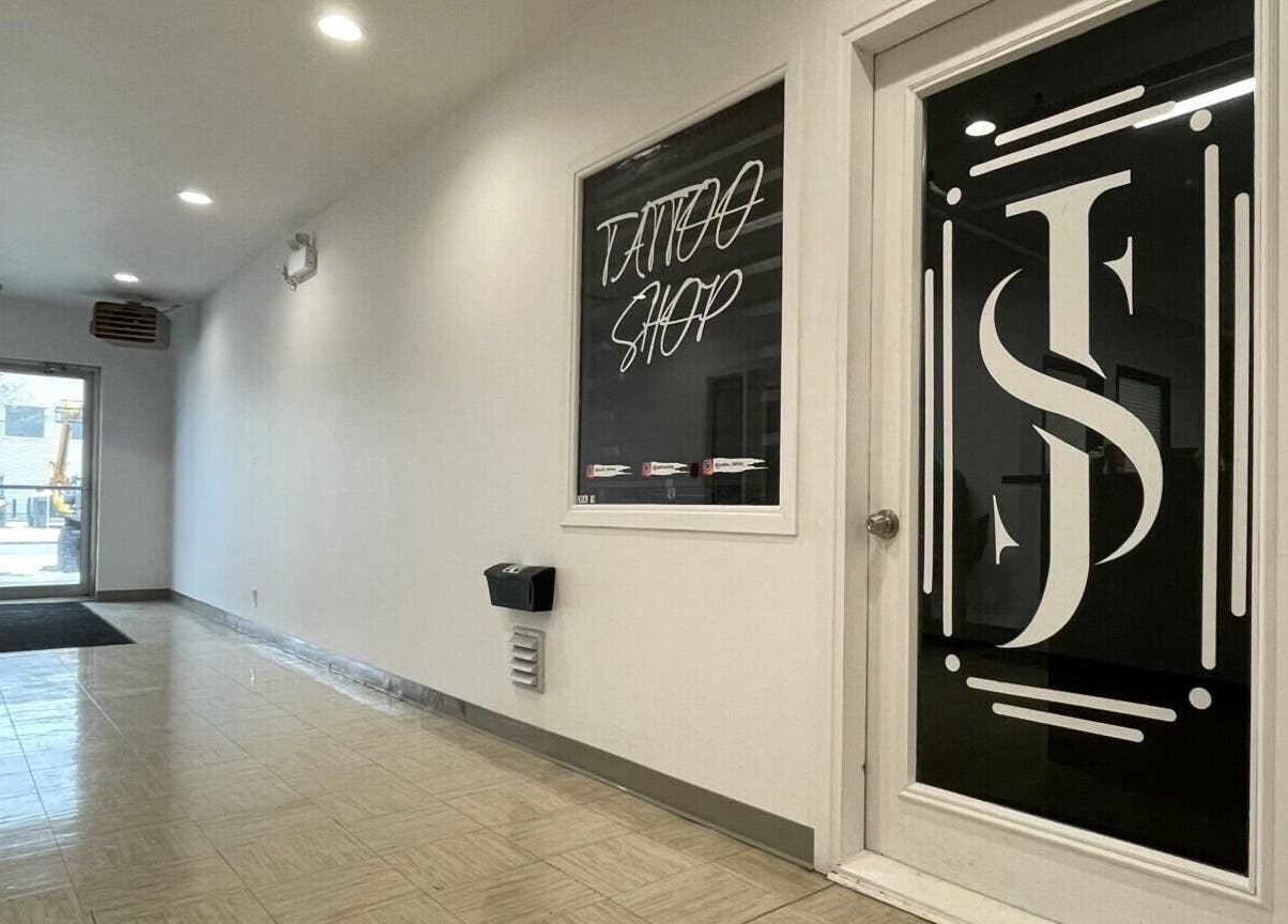 Entrée moderne de Jordan Tattoo à Rimouski, Québec, CA, avec sol brillant et porte vitrée élégante.