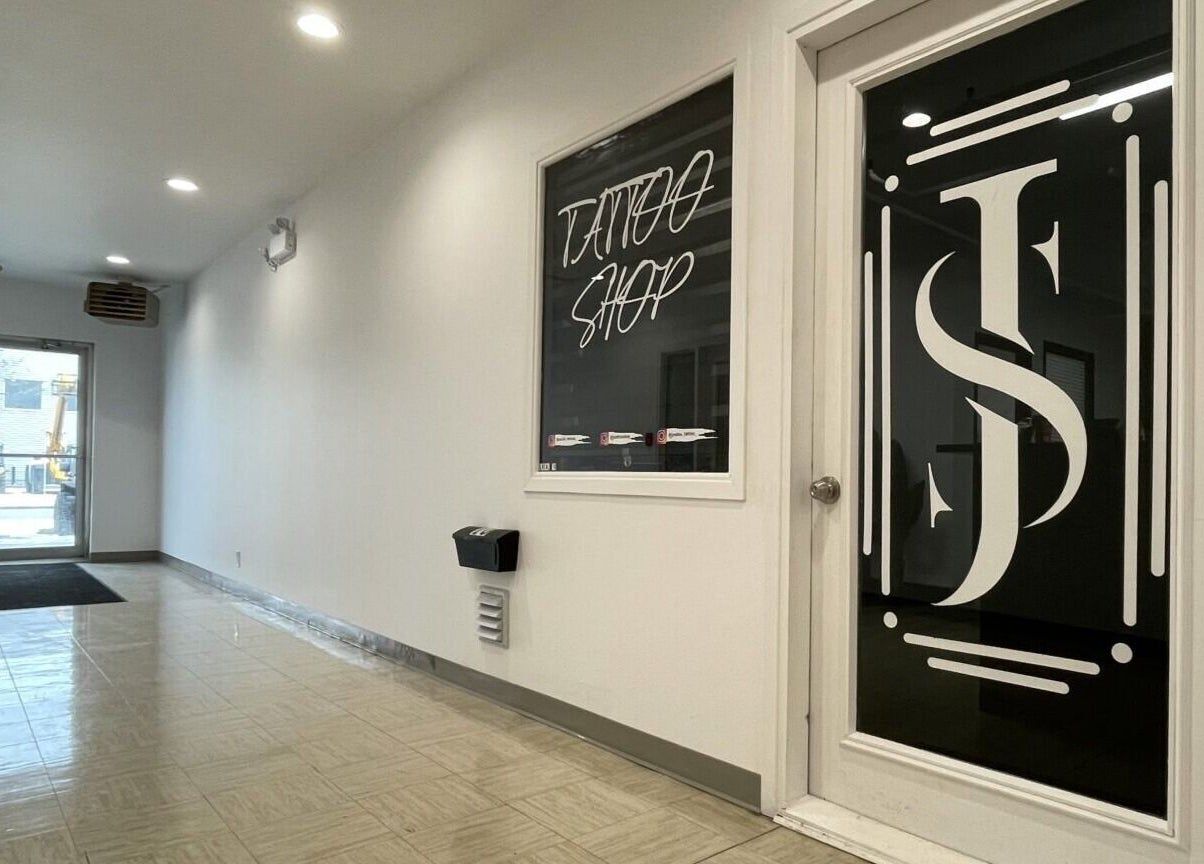 Entrée moderne de Jordan Tattoo à Rimouski, Québec, CA, avec sol brillant et porte vitrée élégante.