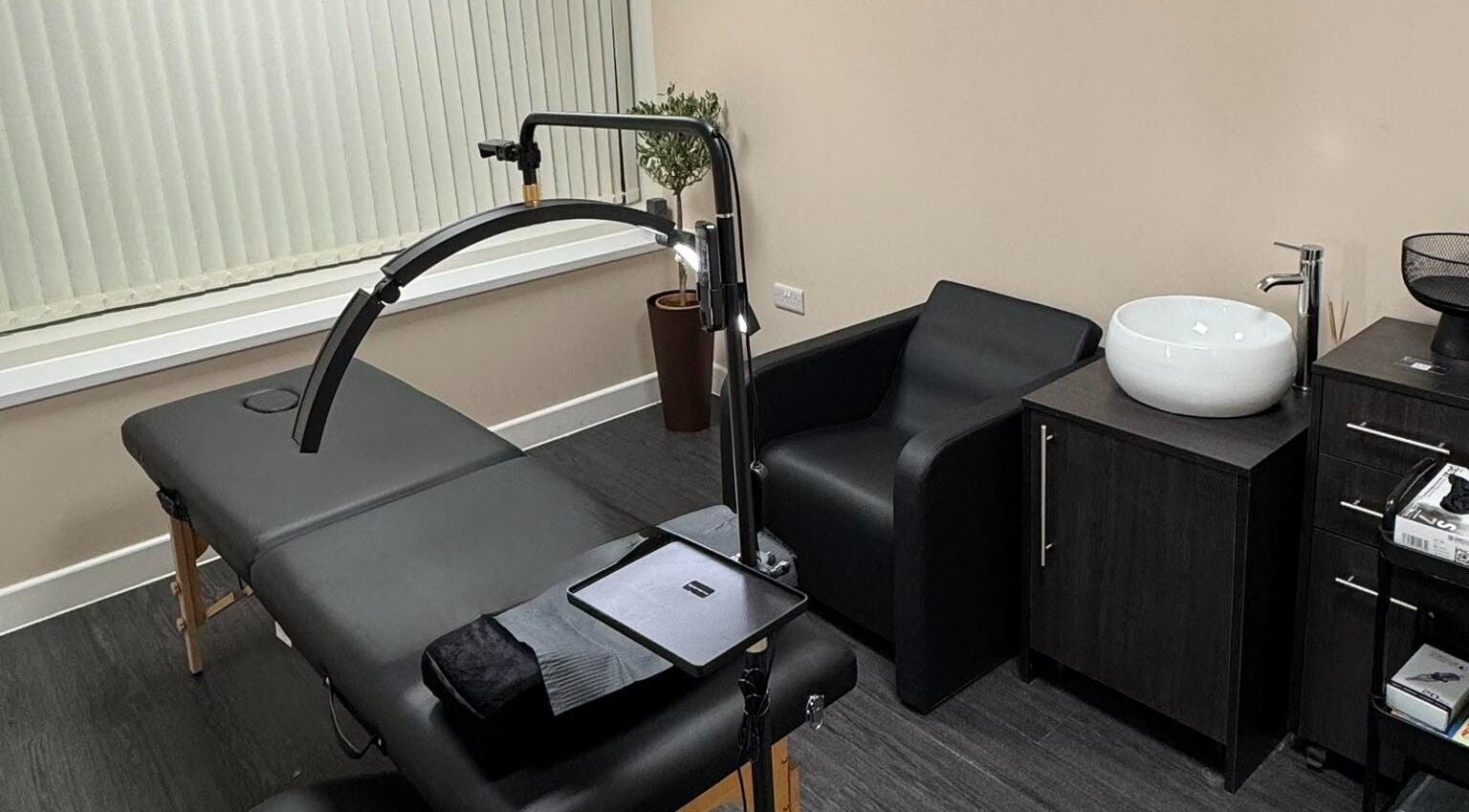 Modern treatment room at ZeZe Beauty Art in Birmingham, England, GB featuring a massage table and sleek decor.