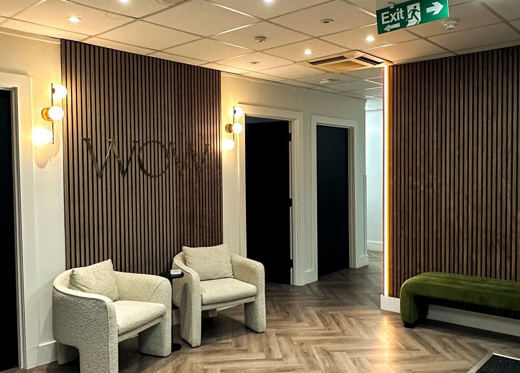 Modern seating area at Elya aesthetic, London, England, GB with stylish lighting and wood panel walls.