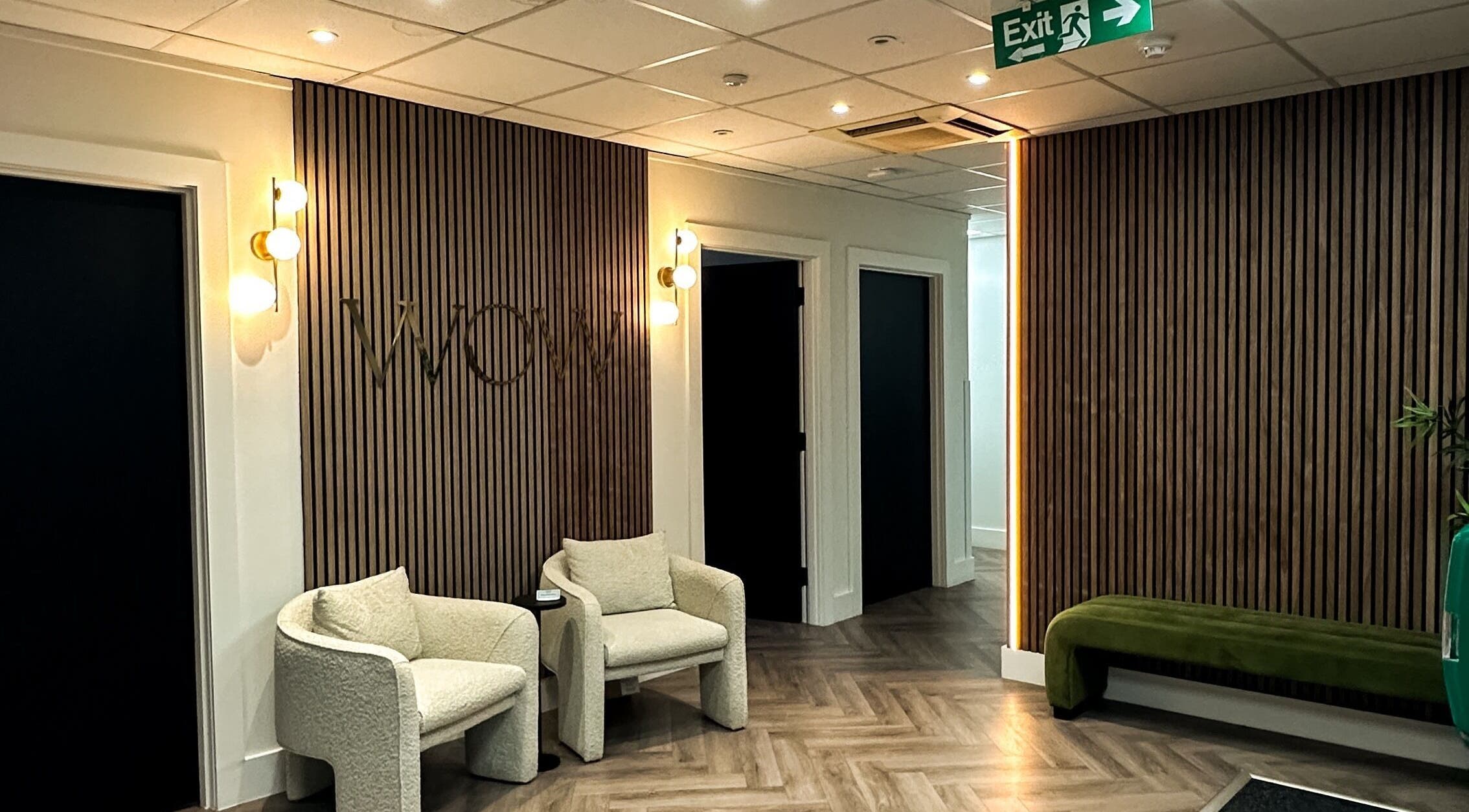 Modern seating area at Elya aesthetic, London, England, GB with stylish lighting and wood panel walls.